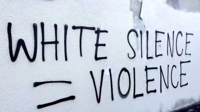 Graffiti that reads "white silence = violence"