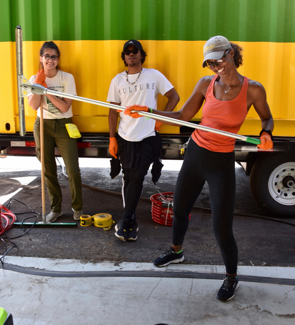 Three volunteers engaging in environmental cleanup