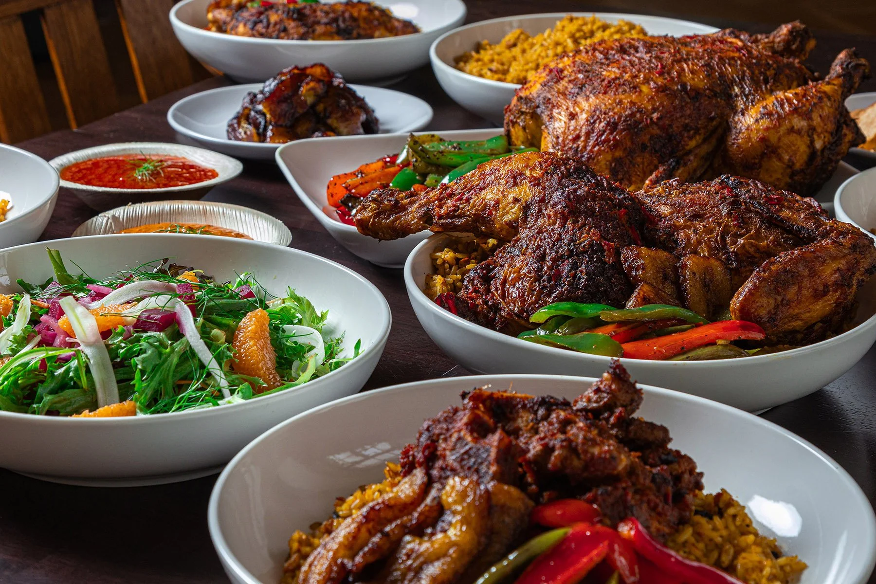 A Sunday Rice Gathering featuring whole roasted chicken, fried plantains, afro-beet salad, steak suya, and chi-town jollof.