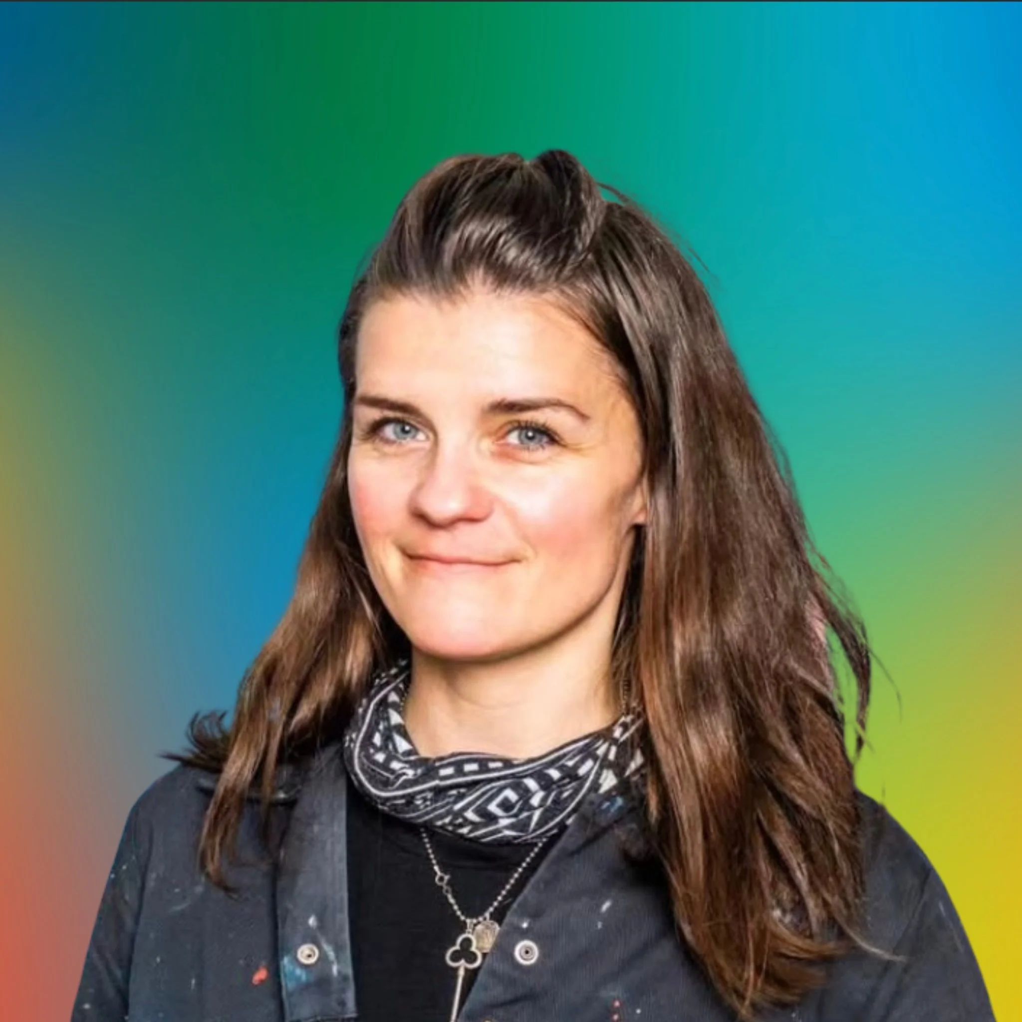 A woman with brown hair, blue eyes, and fair skin, smiling with a colorful gradient background.