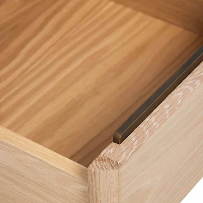Oak wood interior of the Arden Small Bedside Chest, showing off its iron hardware finished in Antique Brass.