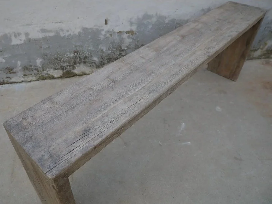 Its naturally weathered surface showcases the rich texture and character of aged wood, while the sturdy legs with iron details provide a modern contrast.