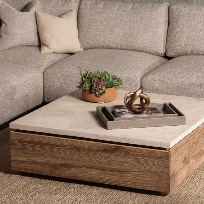 The Branford Storage Cocktail Table placed in front of a grey living room sectional. The table includes a marble top.