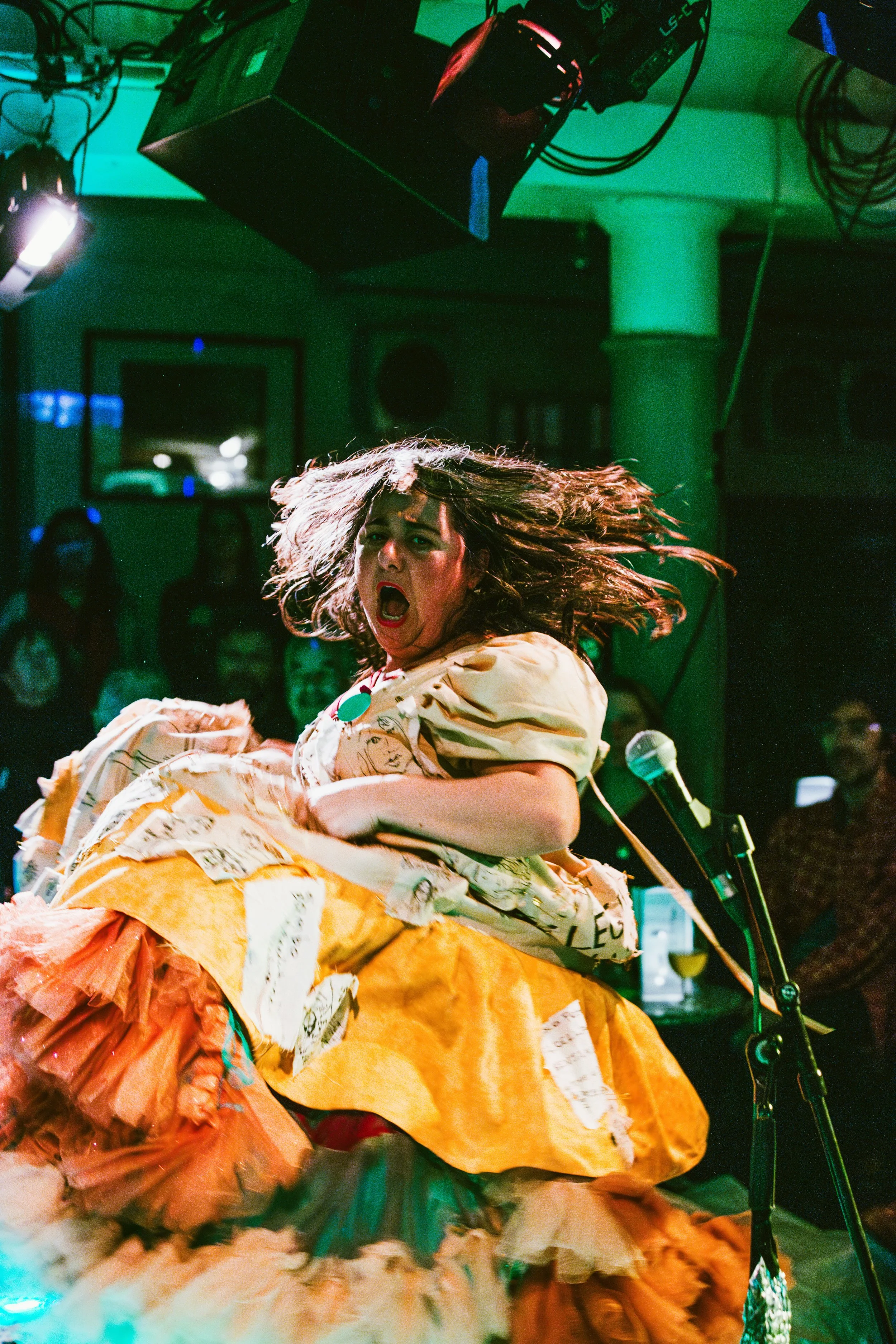 a white woman in a flowing dress with patches of people on it.