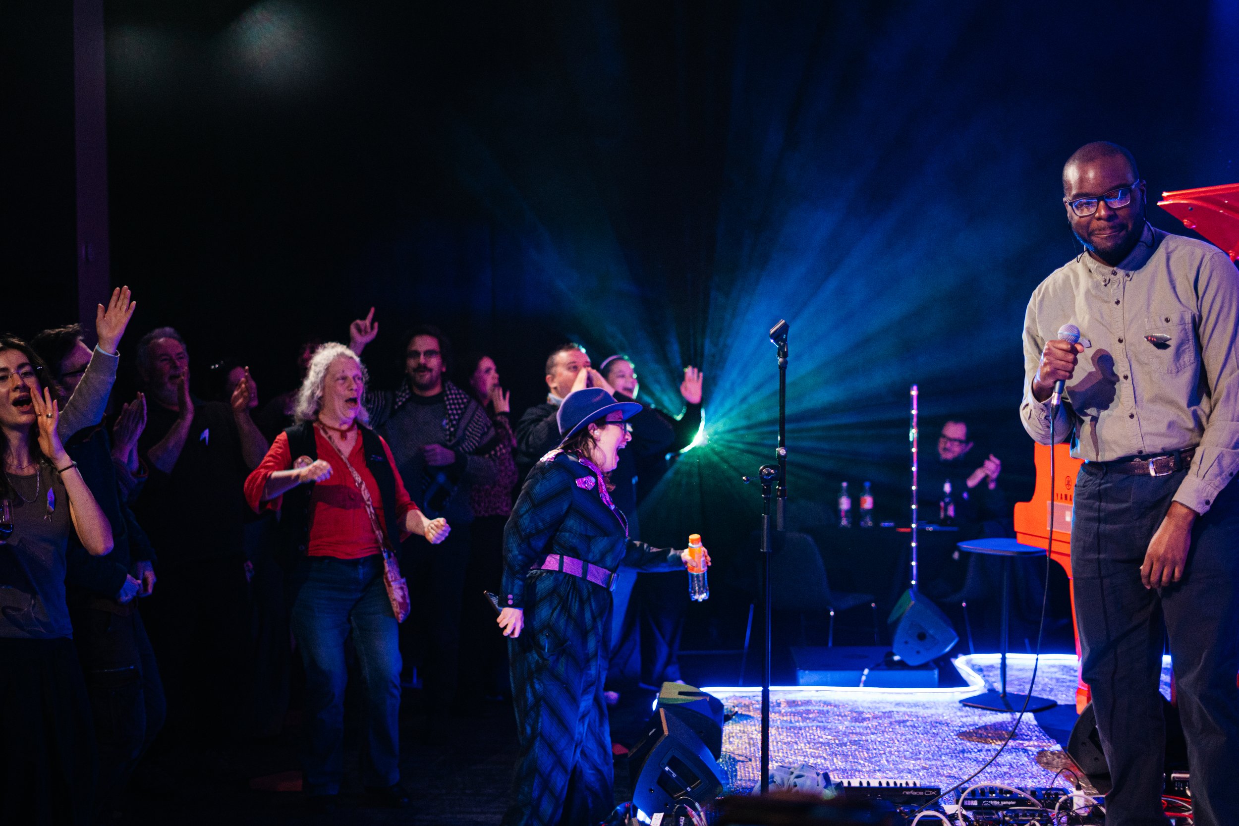  Isaac Palm stood on a stage coverde in silver , with the audiance dancing on the dance floor .Photo by Temi Adegbayibi 