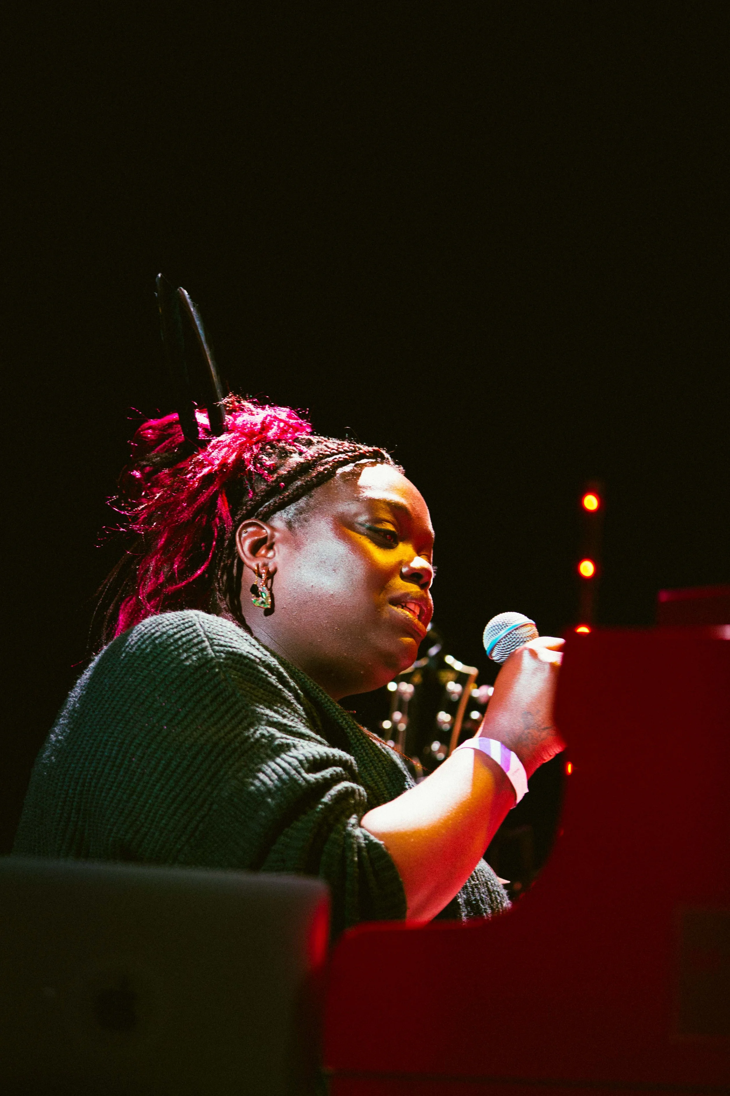 Photo of Donna Thompson singing into a microphone sat at a piano , photo by Sian O Connor 