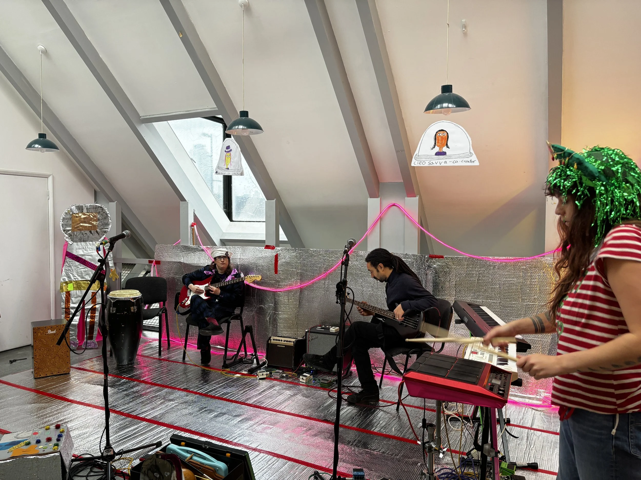 a room with a silver floor with instruments and people playing them.