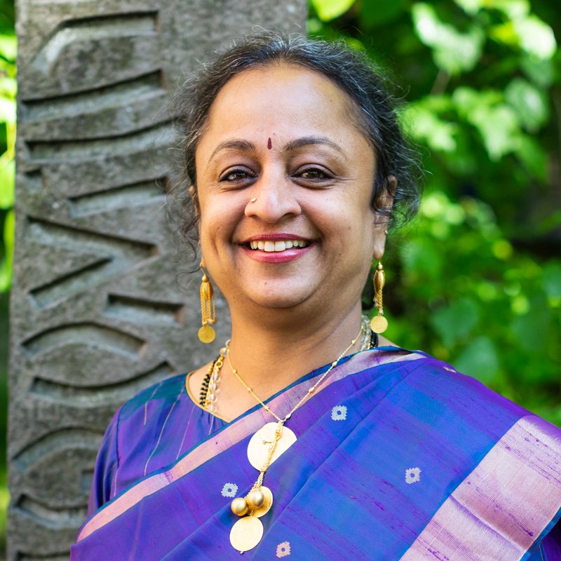 photo of Supriya Nagarajan , a Indian lady in a blue sari , gold neckalce and gold earrings