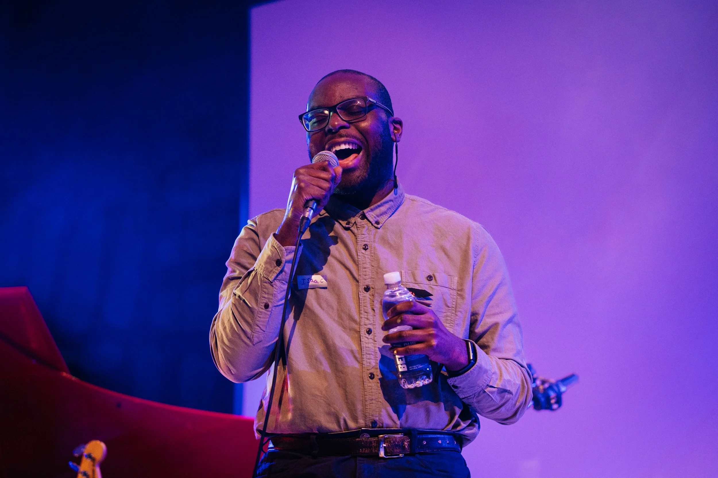Isaac Palm holding a bottle of water and singing . Photo by Temi Adegbayibi 
