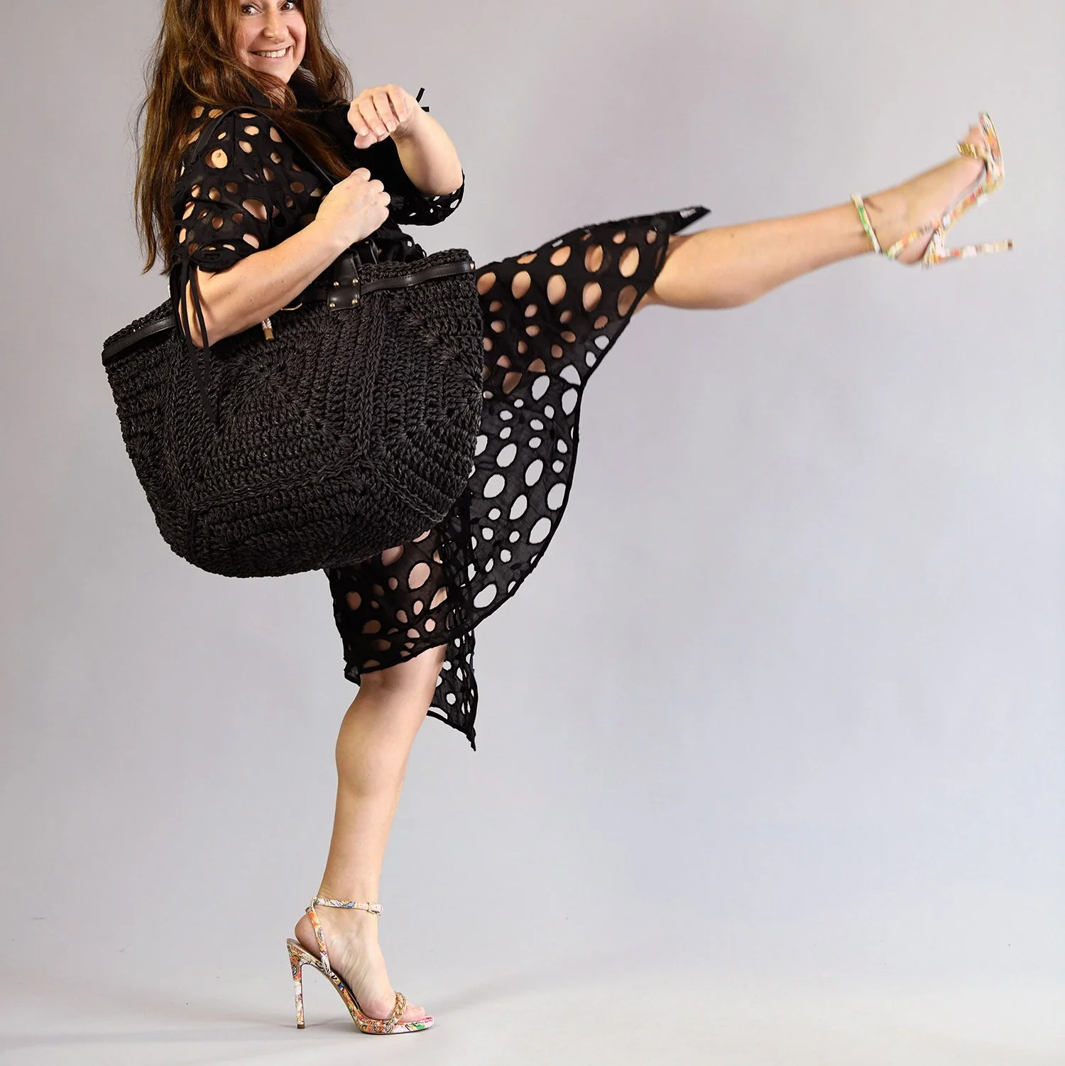 Fashion high kick in studio with black dress and bag.jpg