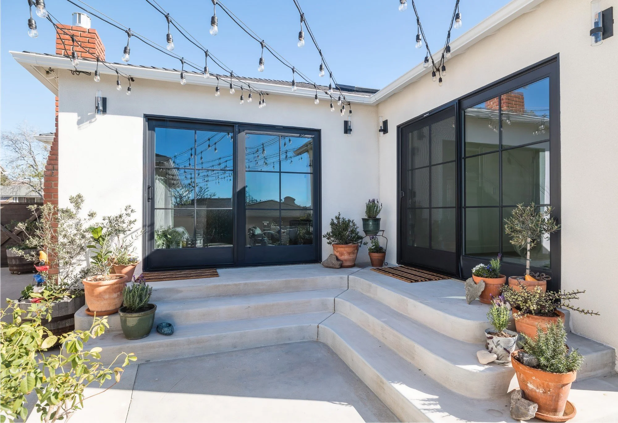 Black frame glass sliding doors open the home to the courtyard