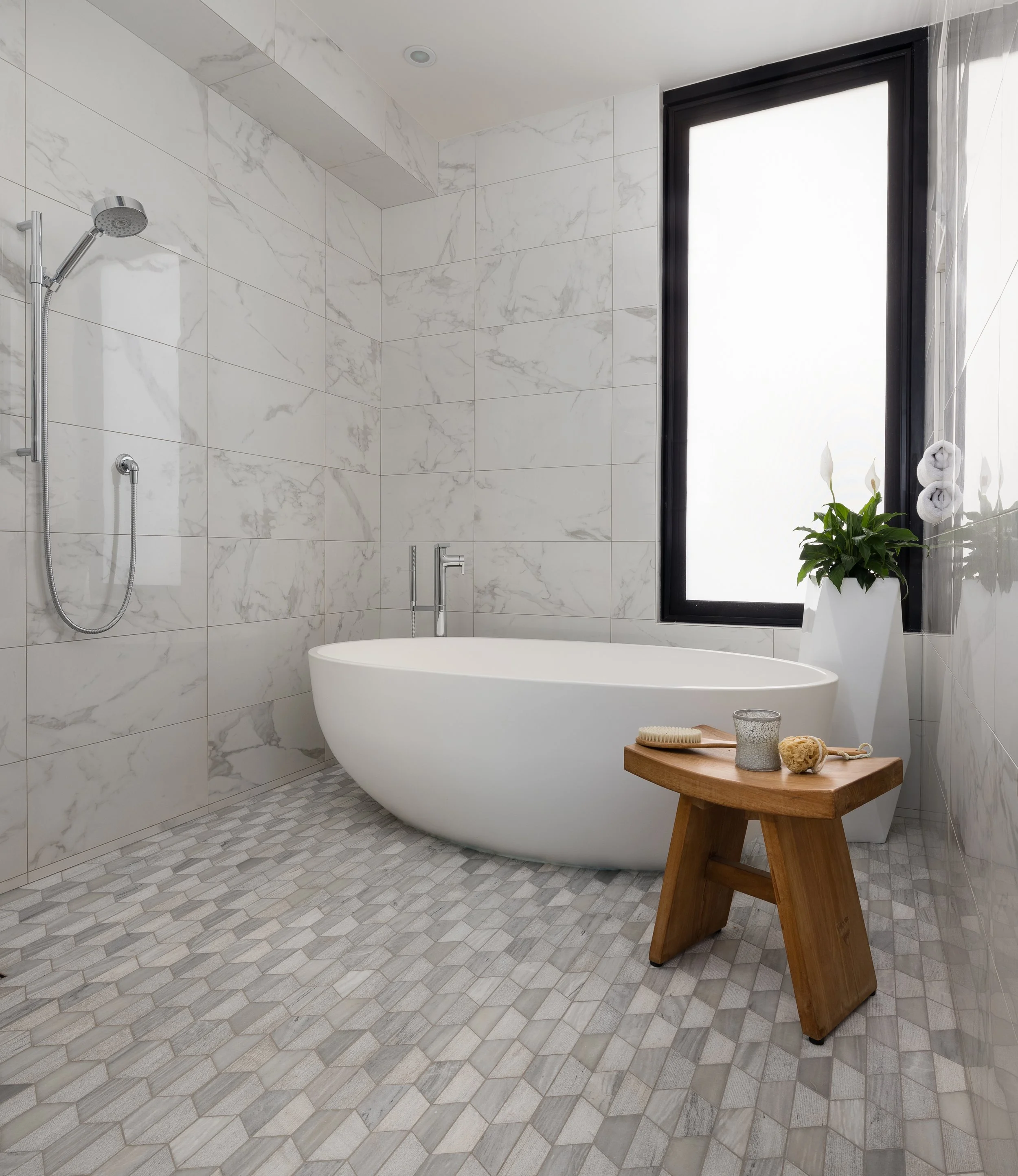 Bathroom with a freestanding oval soaking tub, curbless walk-in shower with handheld showerhead