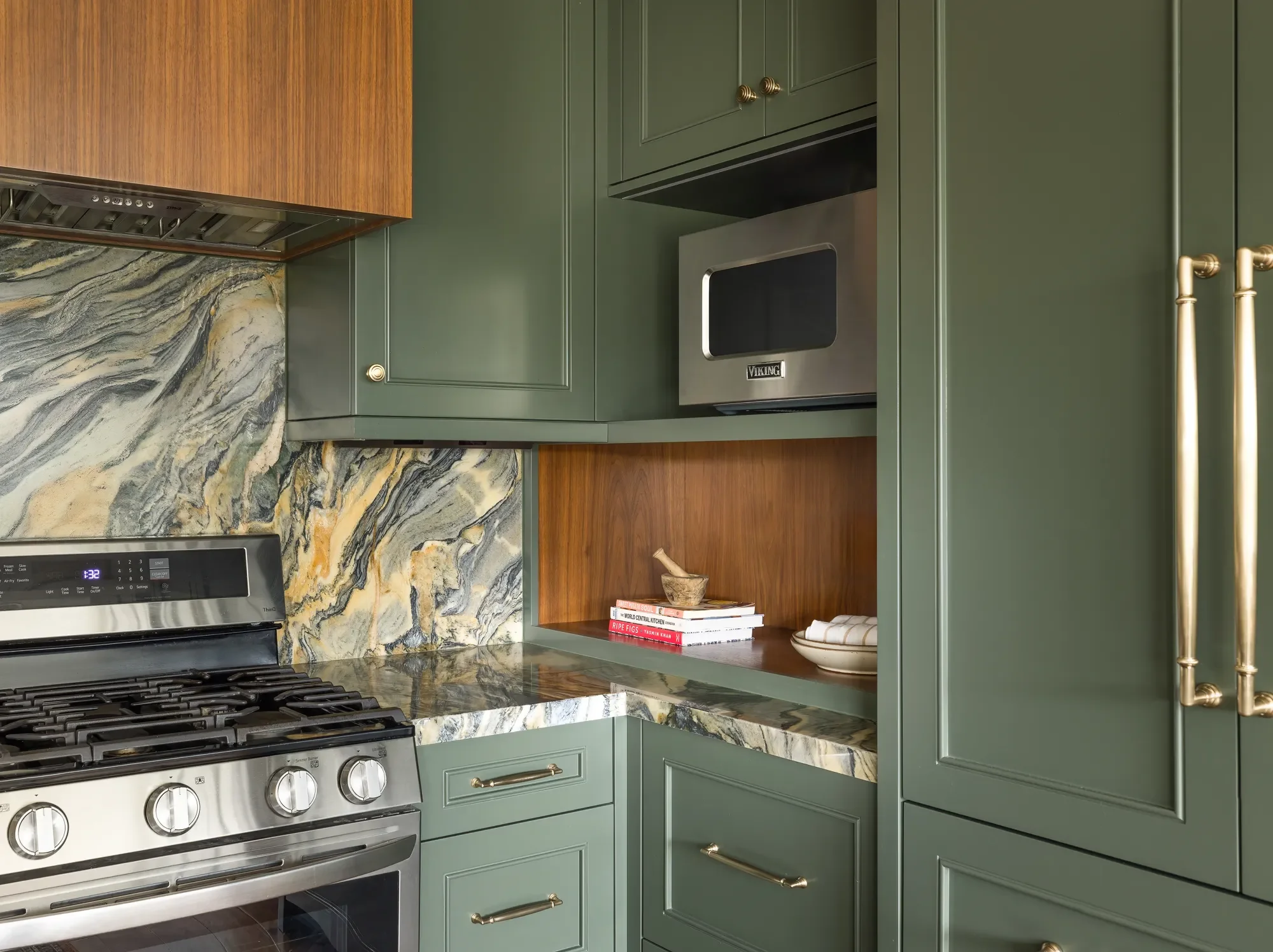 Green cabinetry, marble backsplash, and brass hardware in a Craftsman kitchen to living room transition remodel in Hawthorne