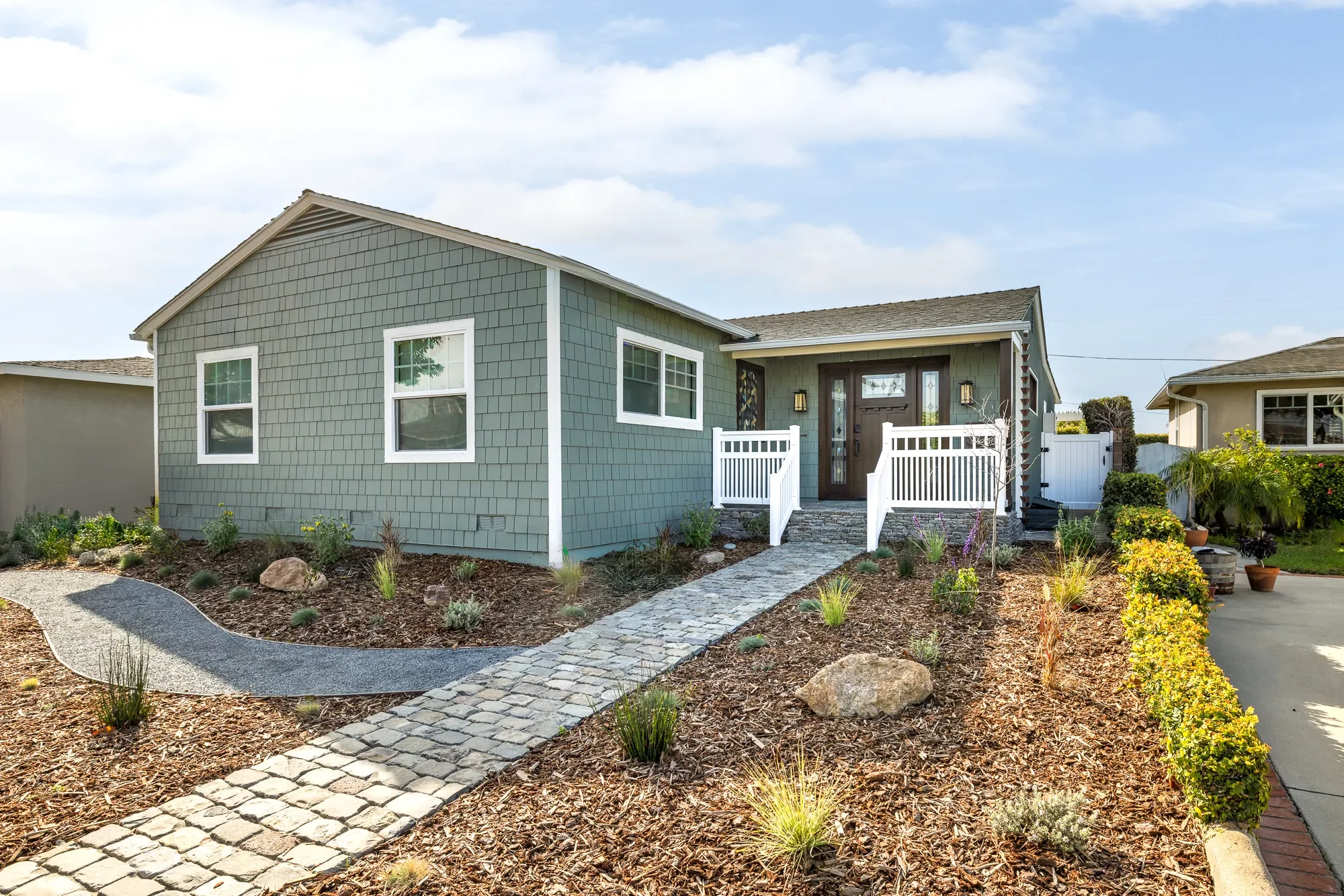 Craftsman bungalow exterior in Hawthorne with drought-tolerant landscaping and stone pathway