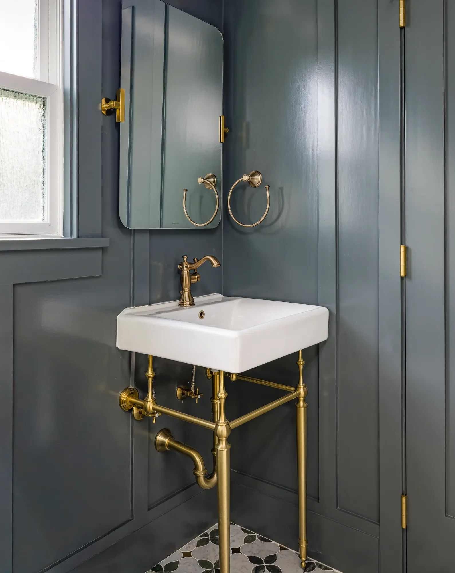 Brass console sink and fixtures in a moody dark green Craftsman guest bathroom