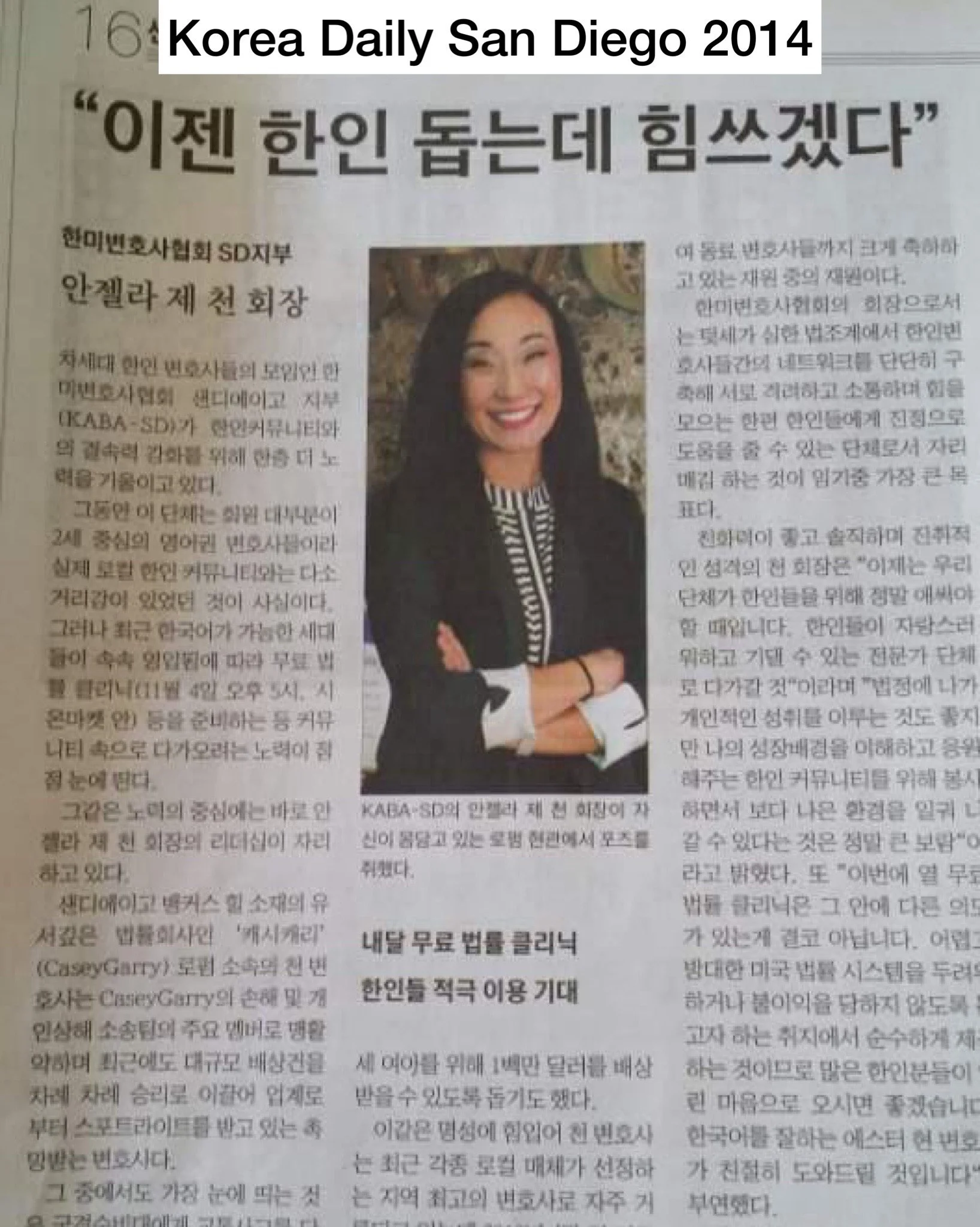 A newspaper article in Korean with a headline about a woman, accompanied by a color photograph of a woman smiling, wearing a black blazer and striped shirt, with crossed arms.