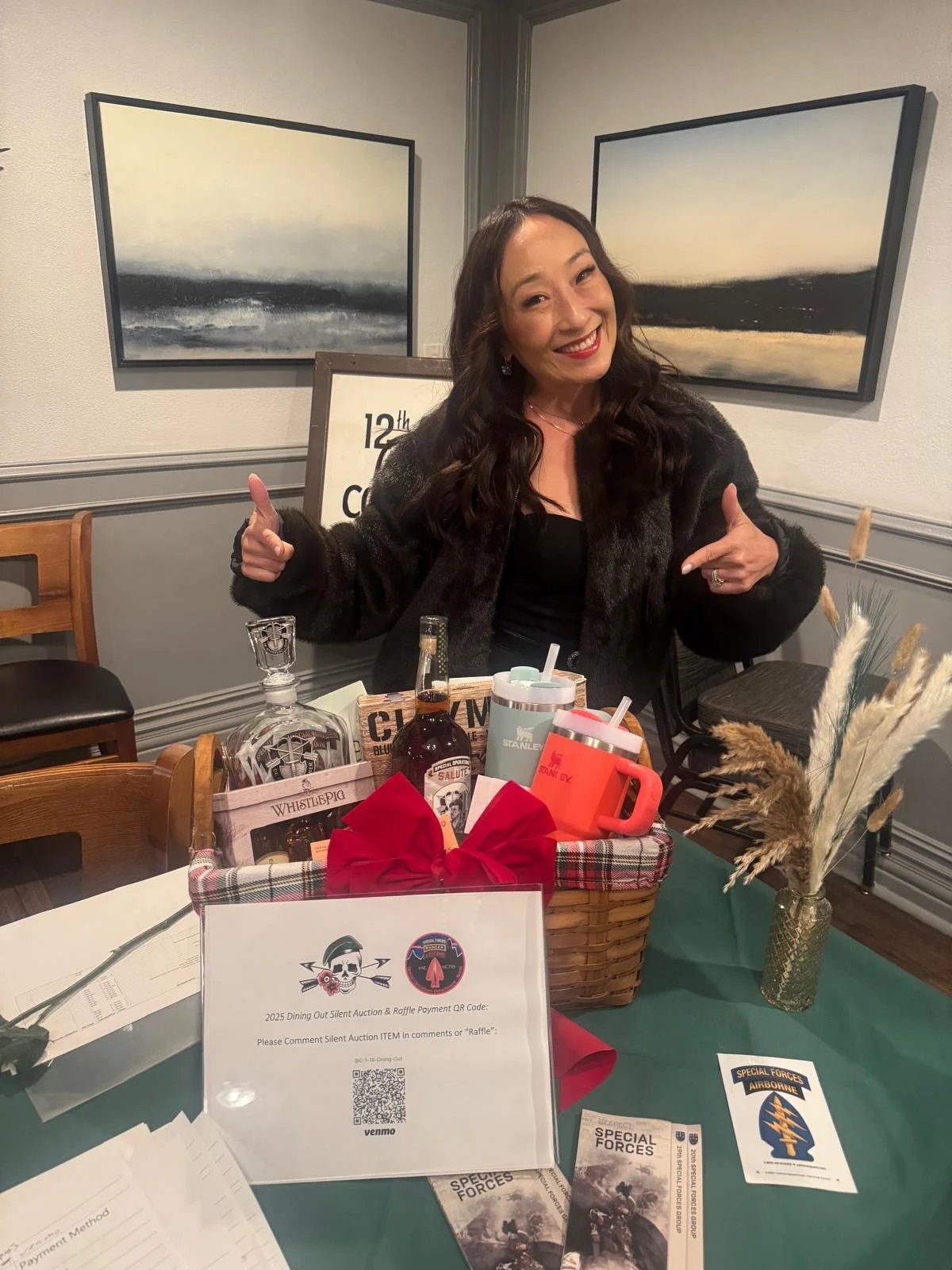A woman is pointing to a gift basket full of gifts
