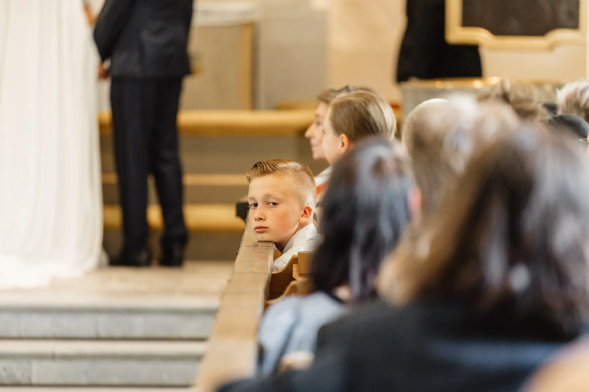 Barn som tittar ut från kyrkbänkar under en ceremoni i en kyrka.