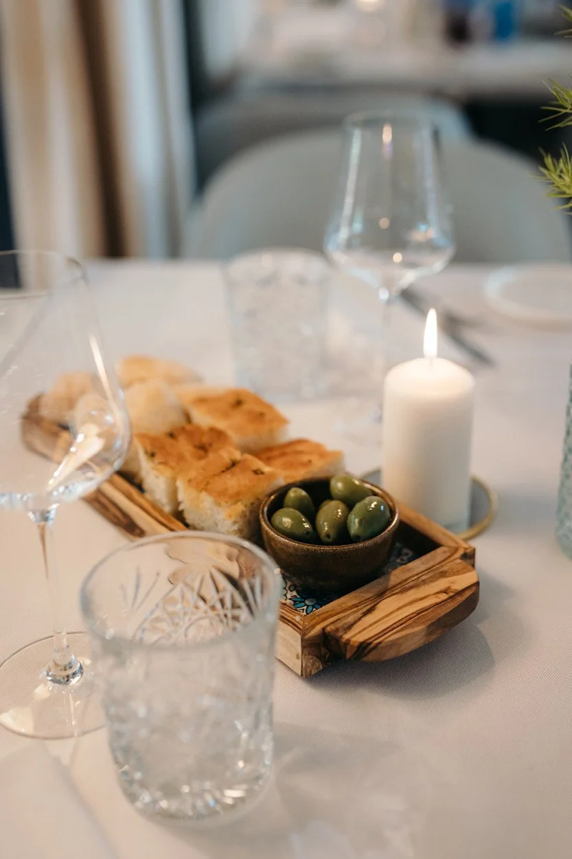 Tischszene mit ANIMO Tapas und Focaccia im Restaurant ANIMO by Aigner