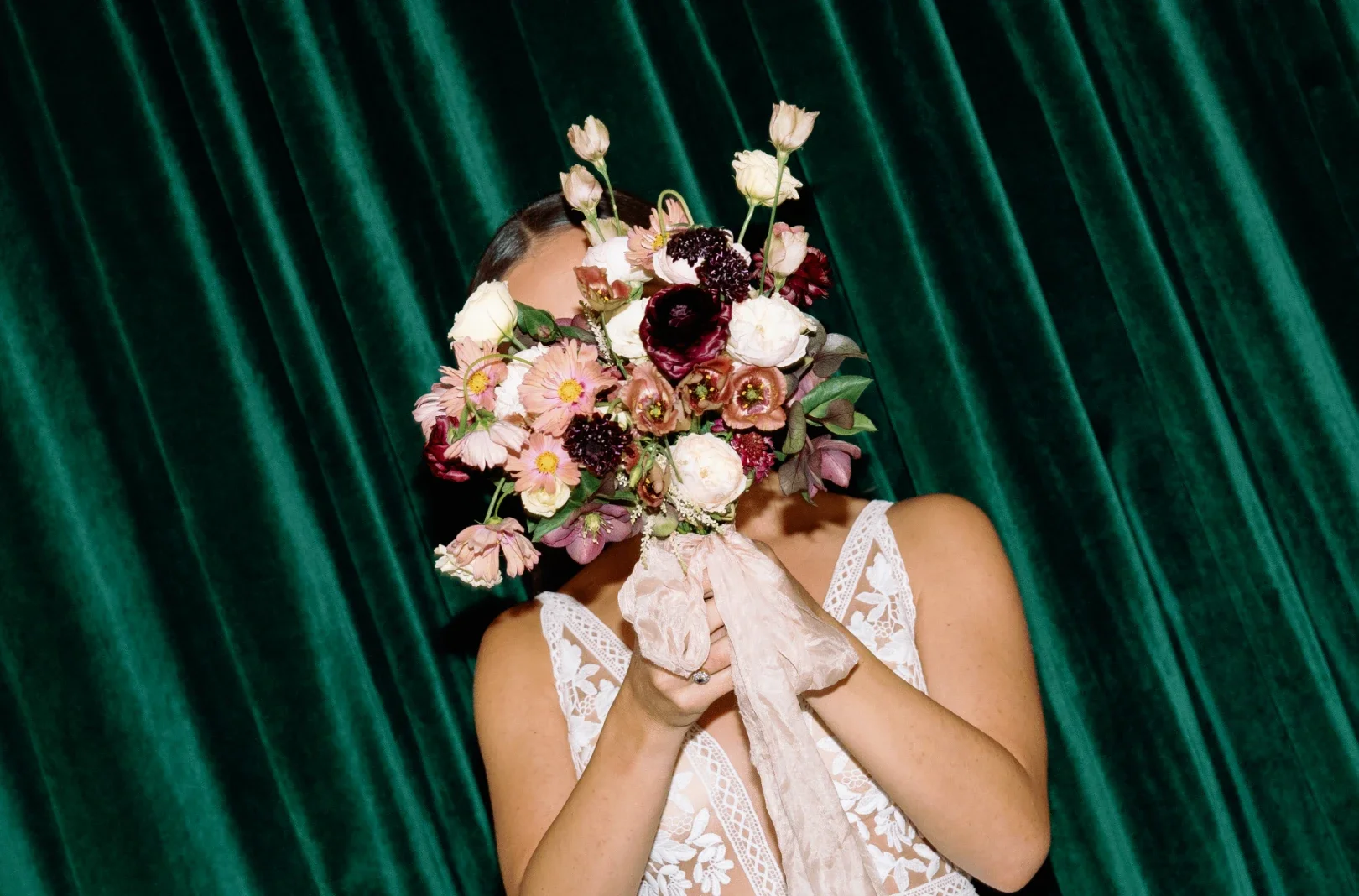 bride holding bouquet in front of face in NYC