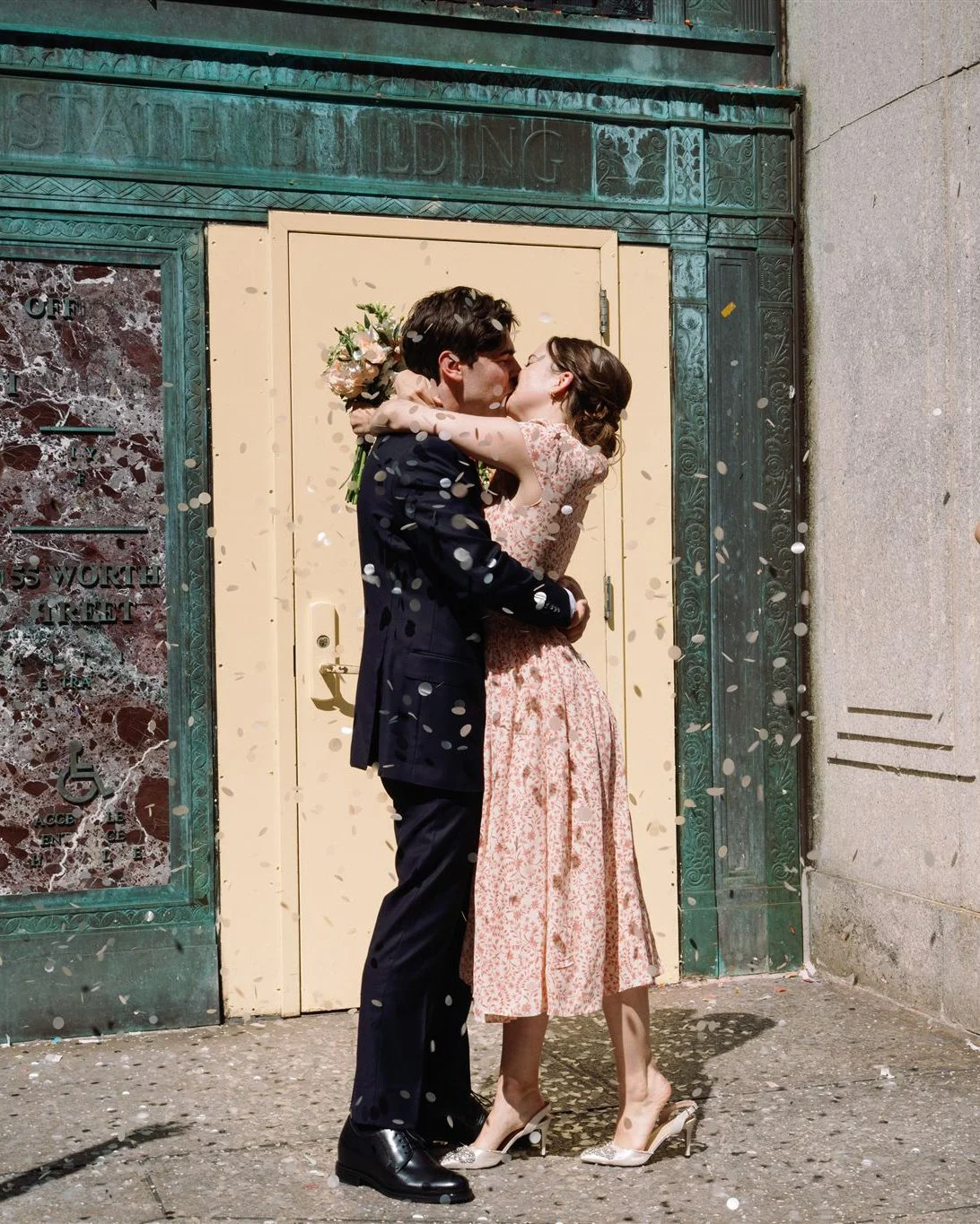 couple kissing in front of nyc city hall building