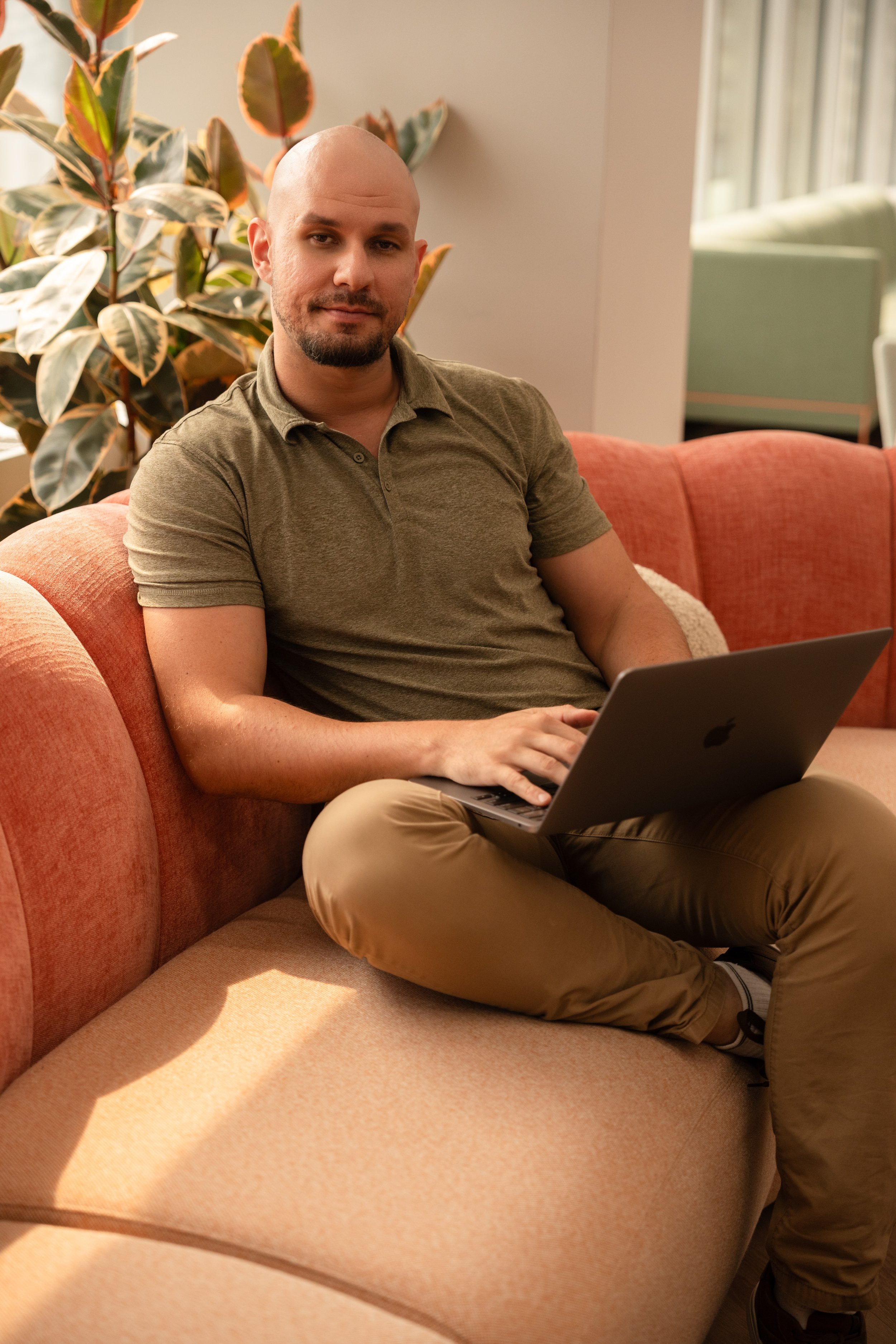 Portrait of man sitting in office on laptop