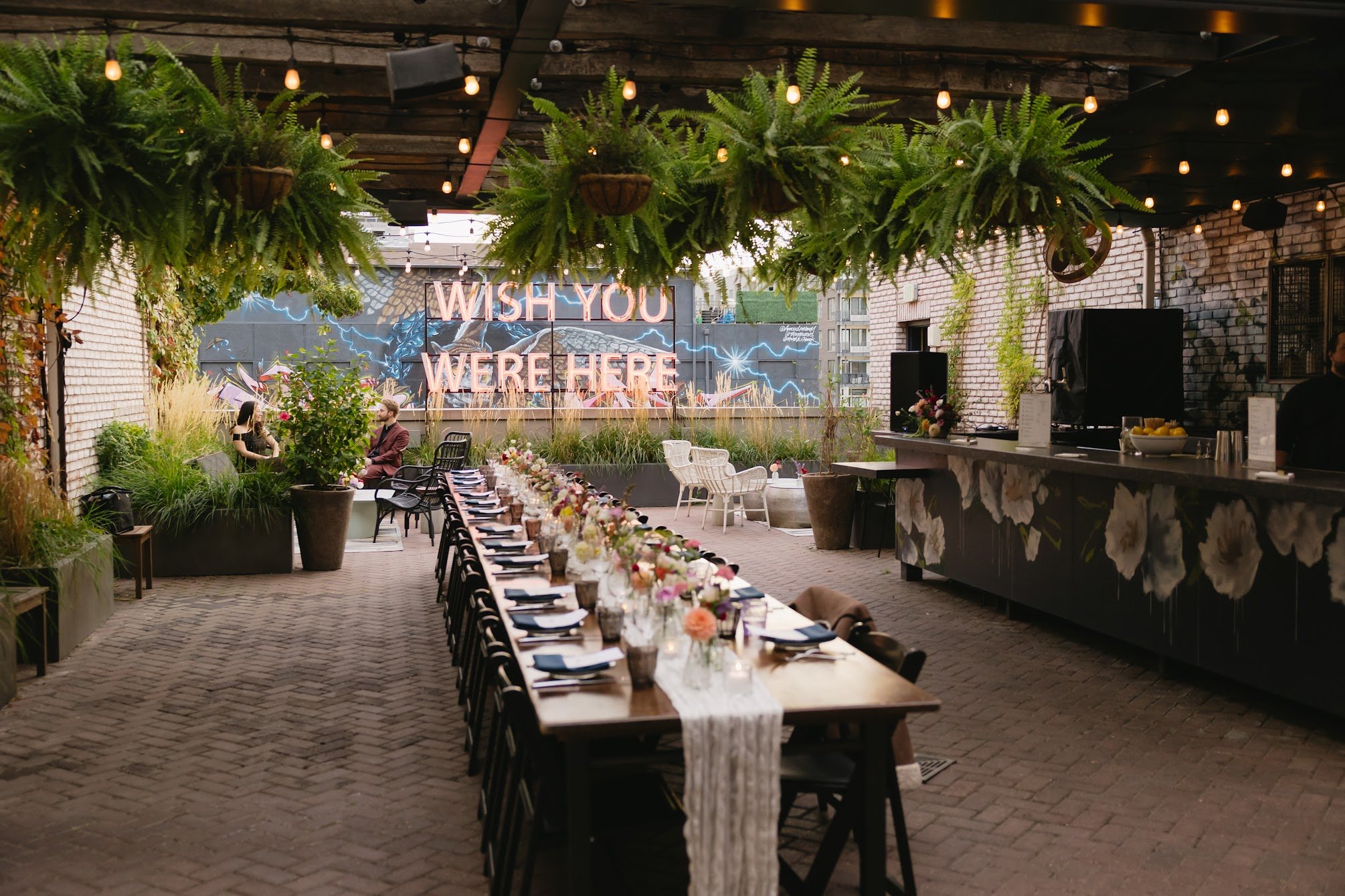Intimate rooftop wedding florals at The Ramble Hotel Denver featuring colorful wildflower bud vases by Brooks Floral Co, photographed by Laur Fernandez.