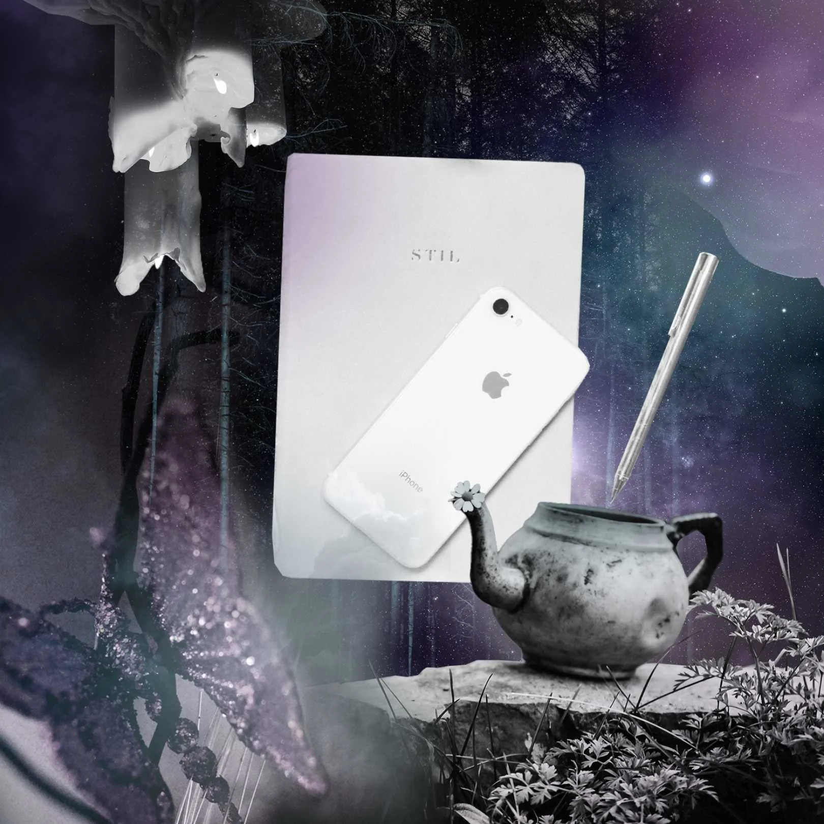A journal with an iphone next to a pen, a teapot, and candles in a purple misty forest