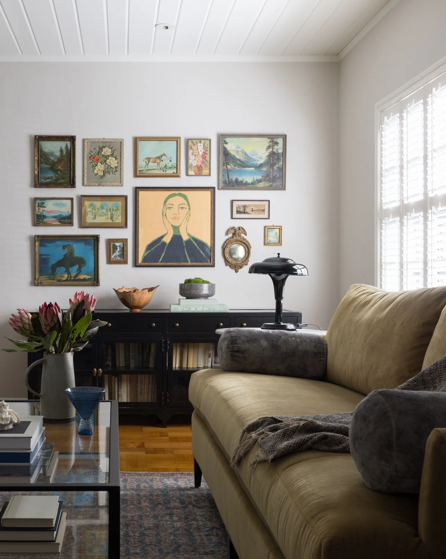 Layered and lived-in. This living room is all about the story on the walls. An eclectic collage that mixes eras, textures, and perspectives to create a space that feels collected, not decorated. 

Design tip: When creating your own gallery wall, don&