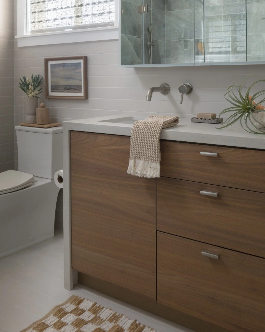 A modern bathroom where texture, light, and movement come together.

The tiled wall creates a clean architectural backdrop, while the waterfall element introduces a sense of calm and connection to nature. Soft tones, natural materials, and minimalist