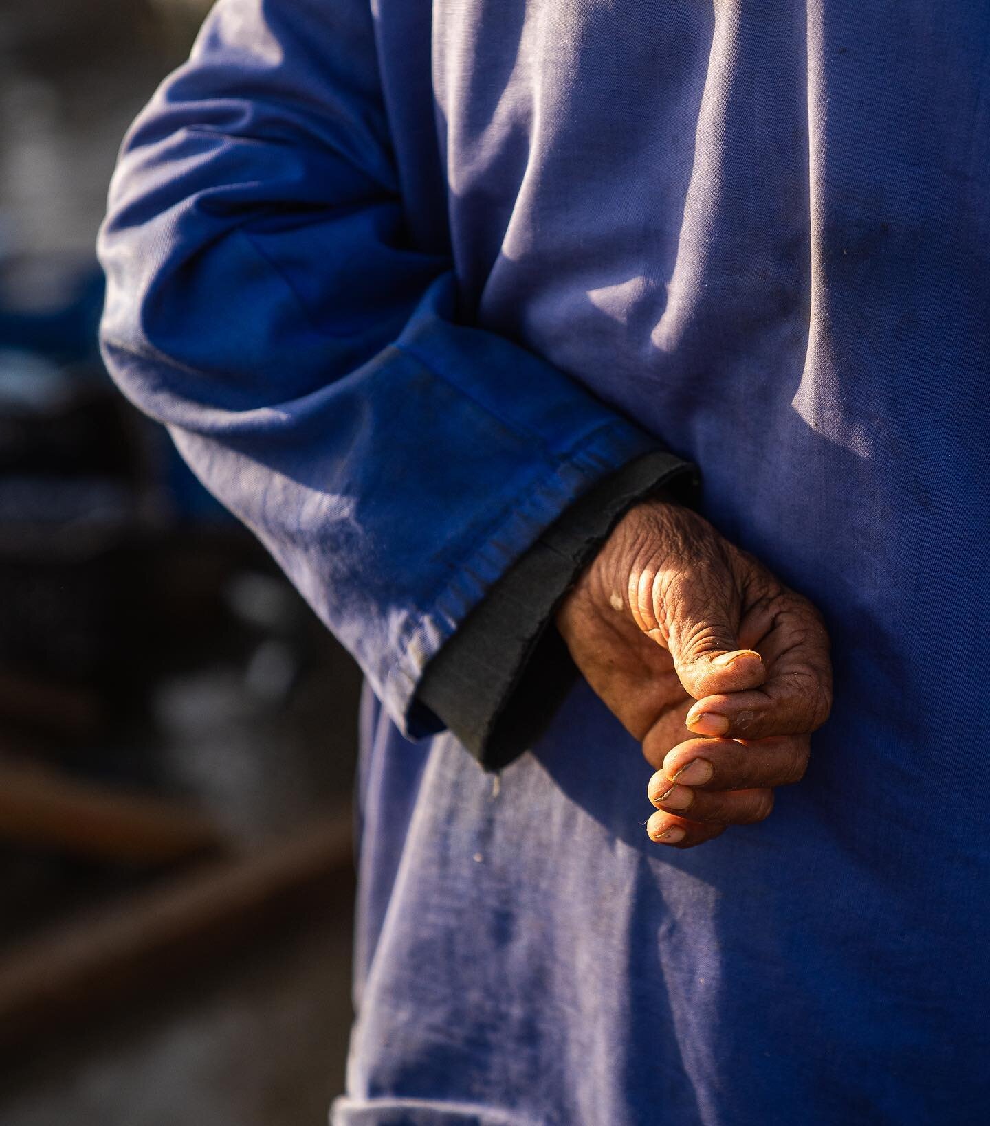 A man stands in the morning warmth as he watches his sons, grandsons and extended family haul fish from their boats. You can see the life of hard work just on his one hand. 

#travel #photojournalism #photography #fishing #family #work #ocean