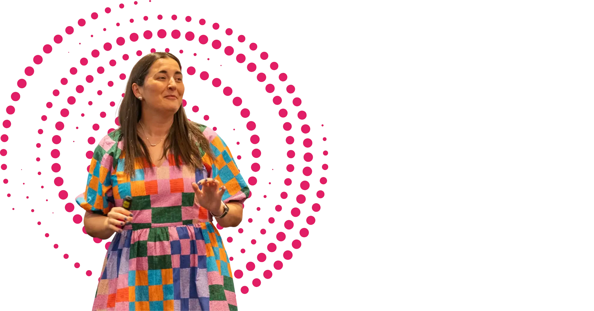 A picture of Dr Selena Fisk, a woman with long brown hair in a brightly coloured dress, smiling while delivering a keynote presentation.