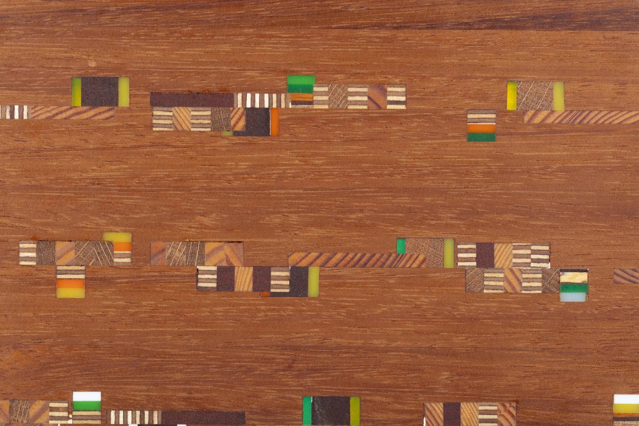 A wooden surface with scattered pieces of a board game or puzzle, featuring various colors and patterns.