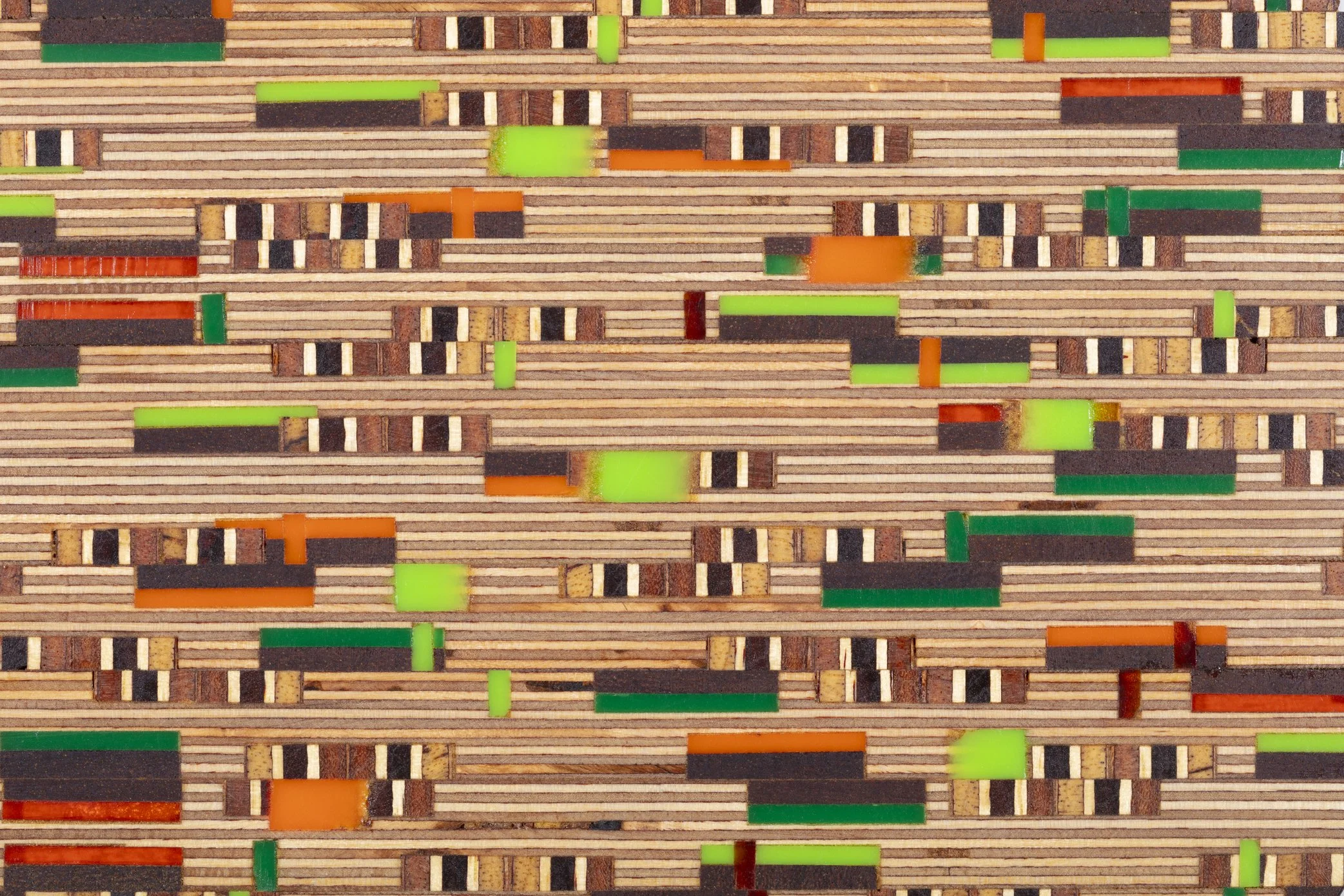 Close-up of a colorful wooden mosaic with horizontal and vertical strips, dots, and blocks in green, orange, black, brown, and beige colors.