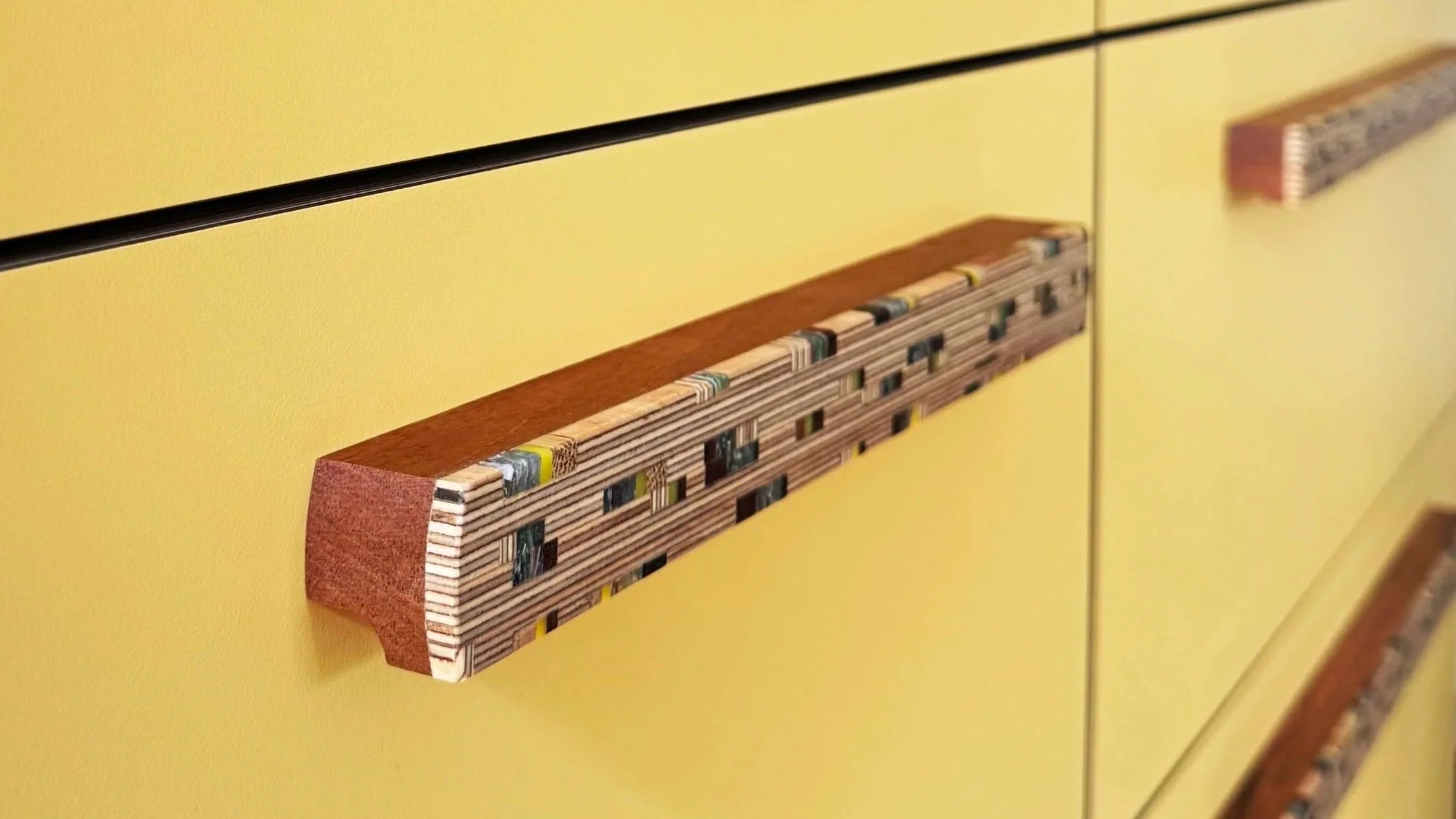 patterned cabinet handle on yellow drawer front