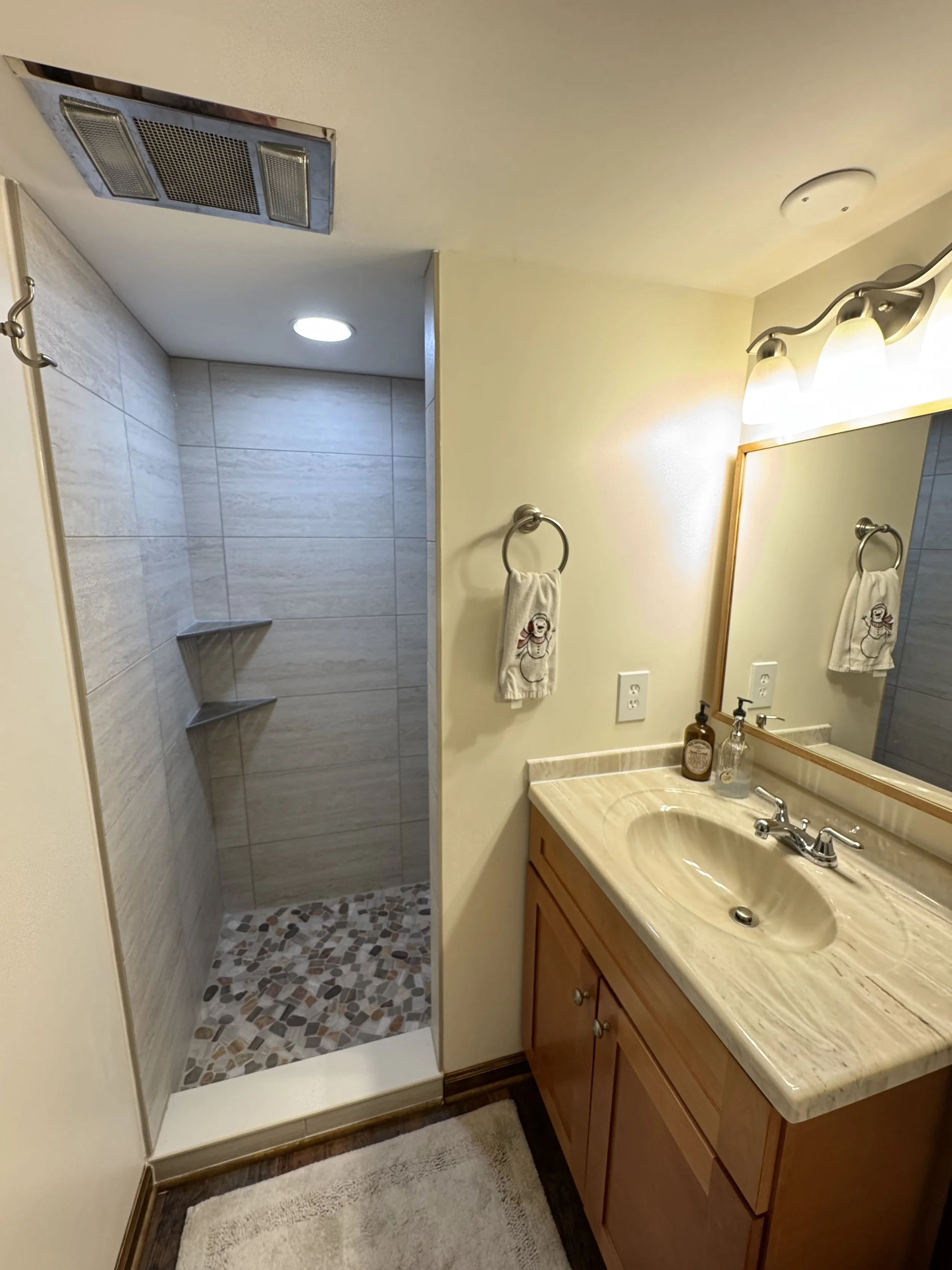 Completed - fully tiled shower with river rock pan.