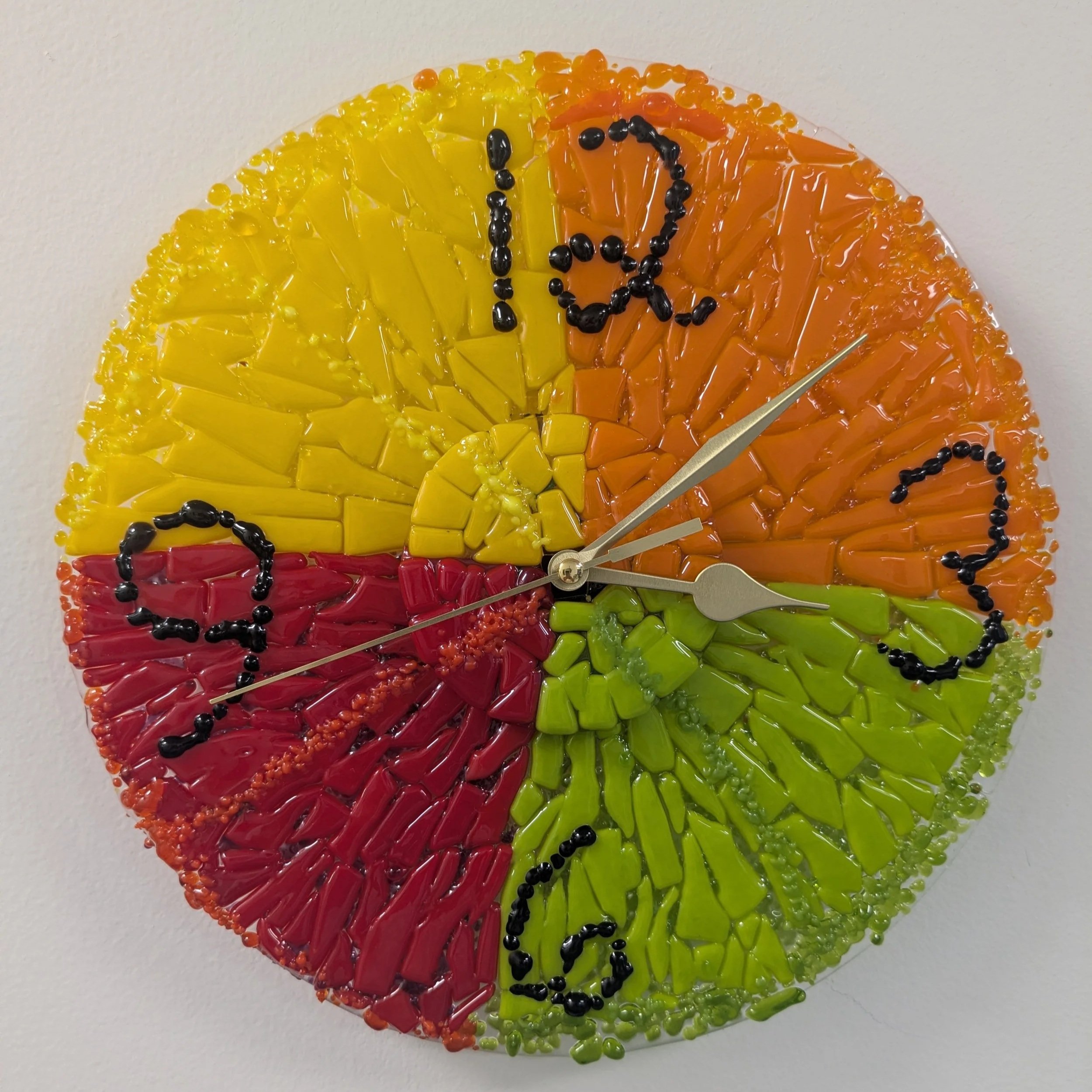 Round clock with glass face in yellow, orange, green and red