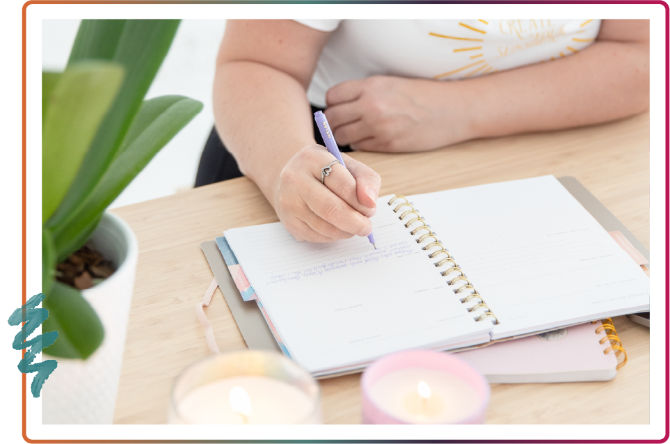Close up of Stephanie writing in a notebook at a desk