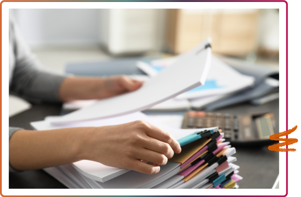 Someone holding a stack of papers and sorting through documents