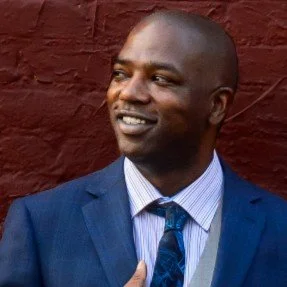 Rai-mon smiling looking into the distance