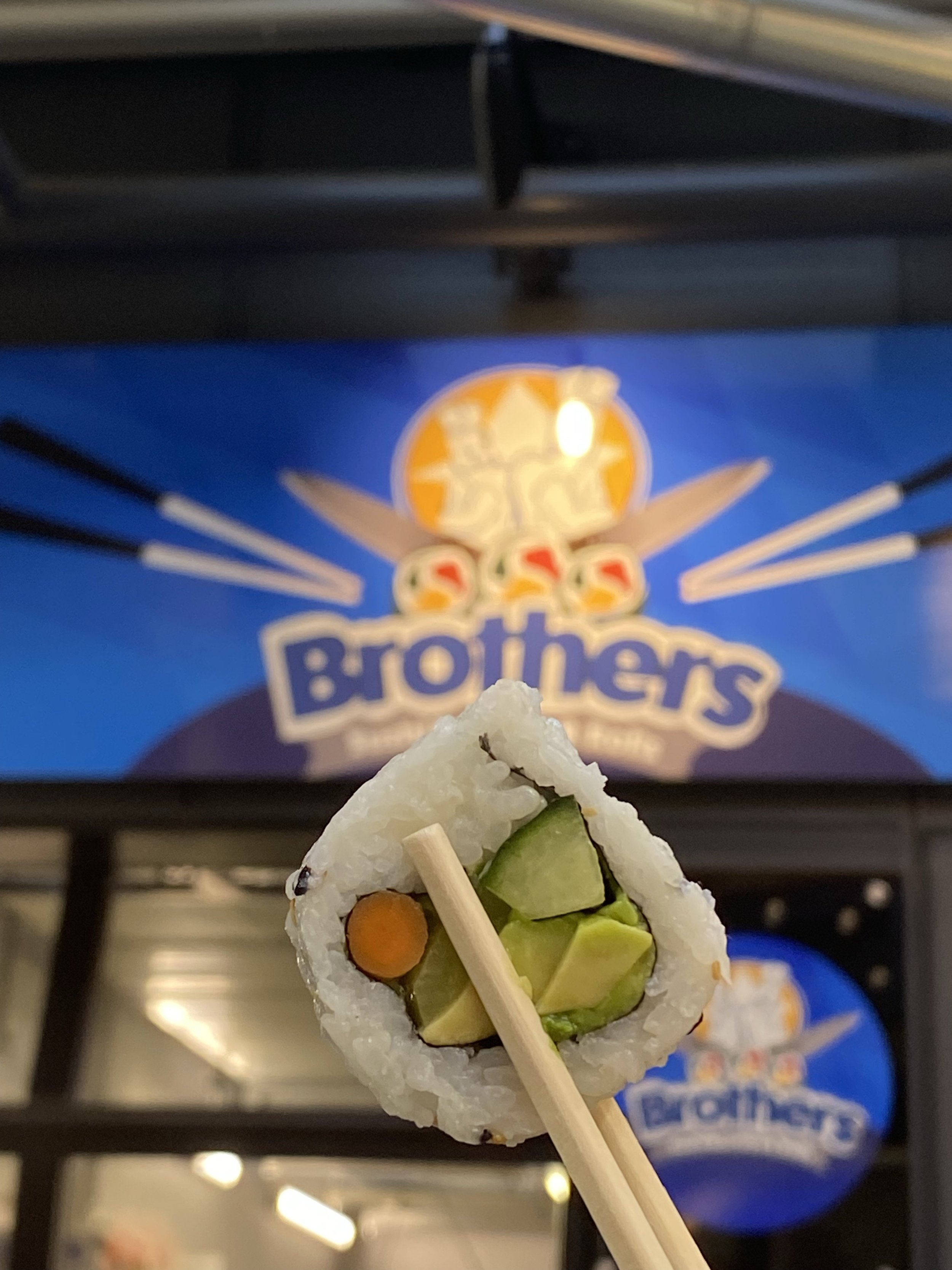 Piece of Sushi in front of Brother Sushi Burritos and Rolls logo