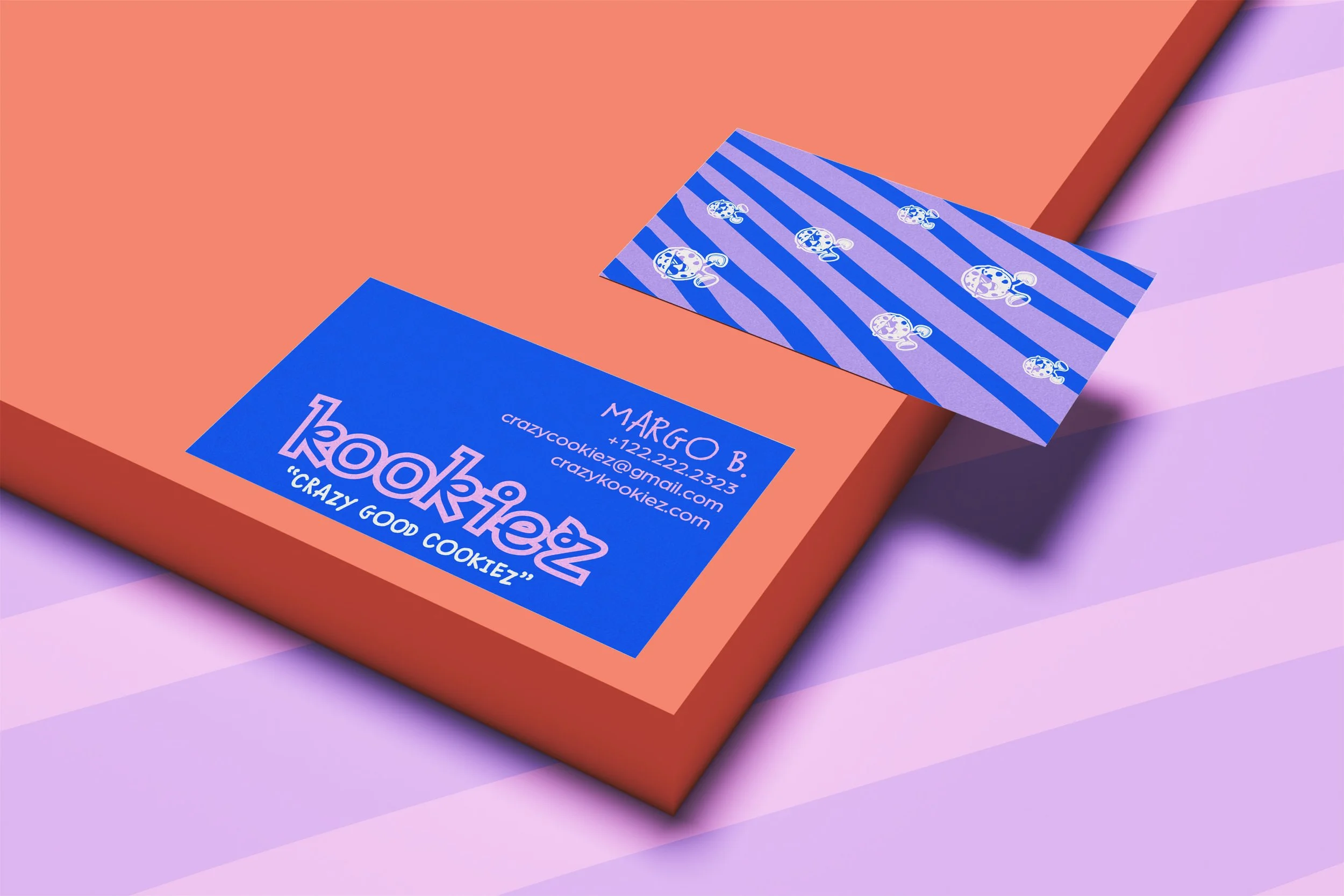 Business card and colorful patterned paper on a pastel pink and purple background, part of a solar system themed business card for Crazy Cookiez with contact details