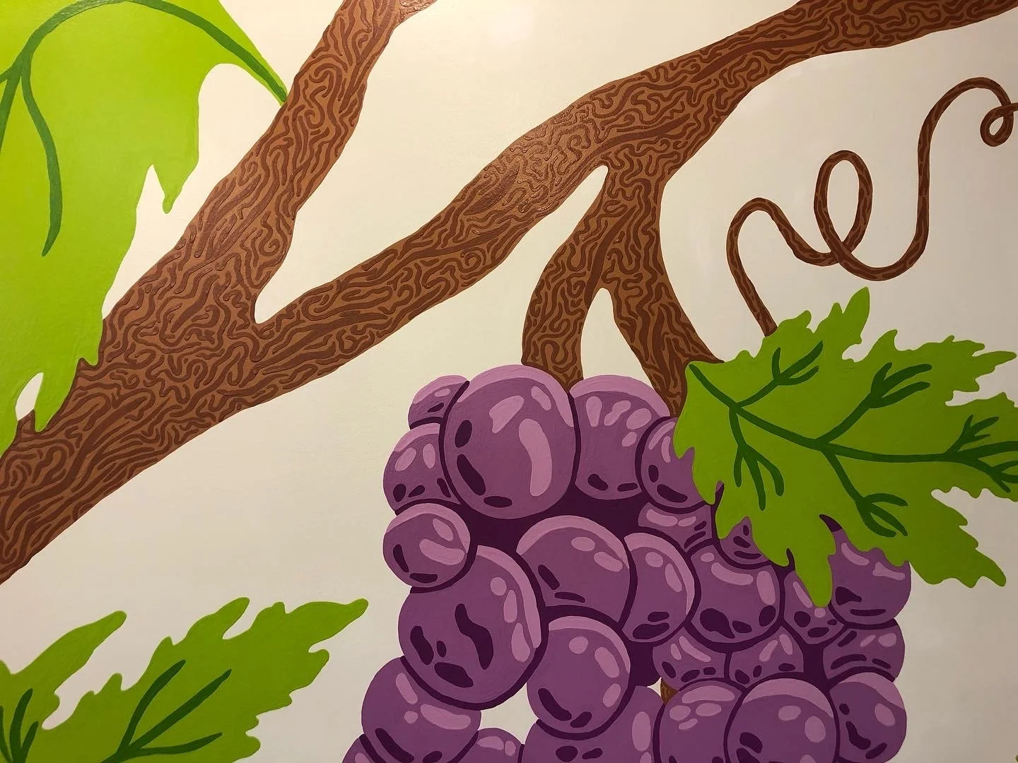 close up of big purple grapes, branches, and leaves painted on the wall