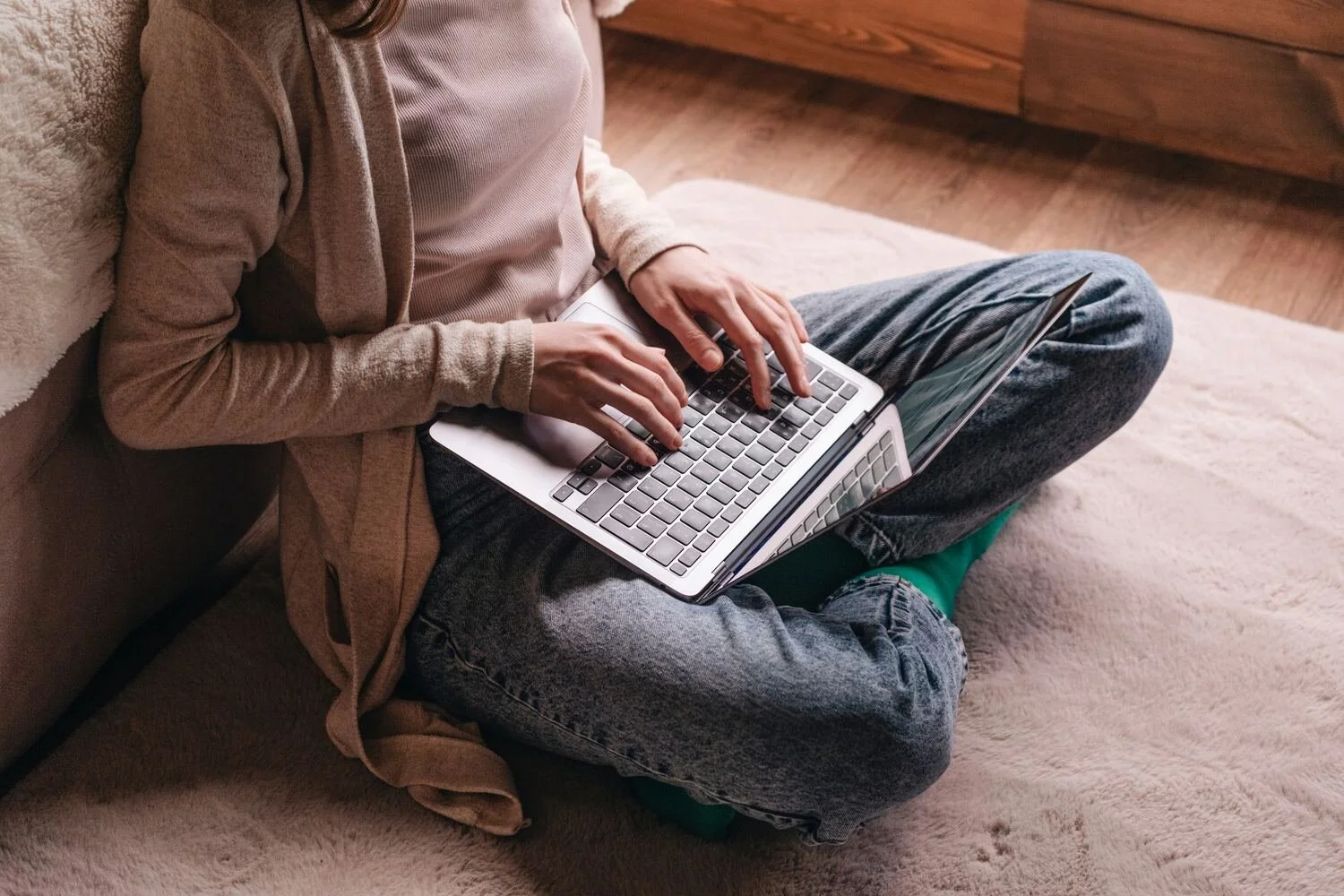 woman sitting on floor with a laptop in her lap