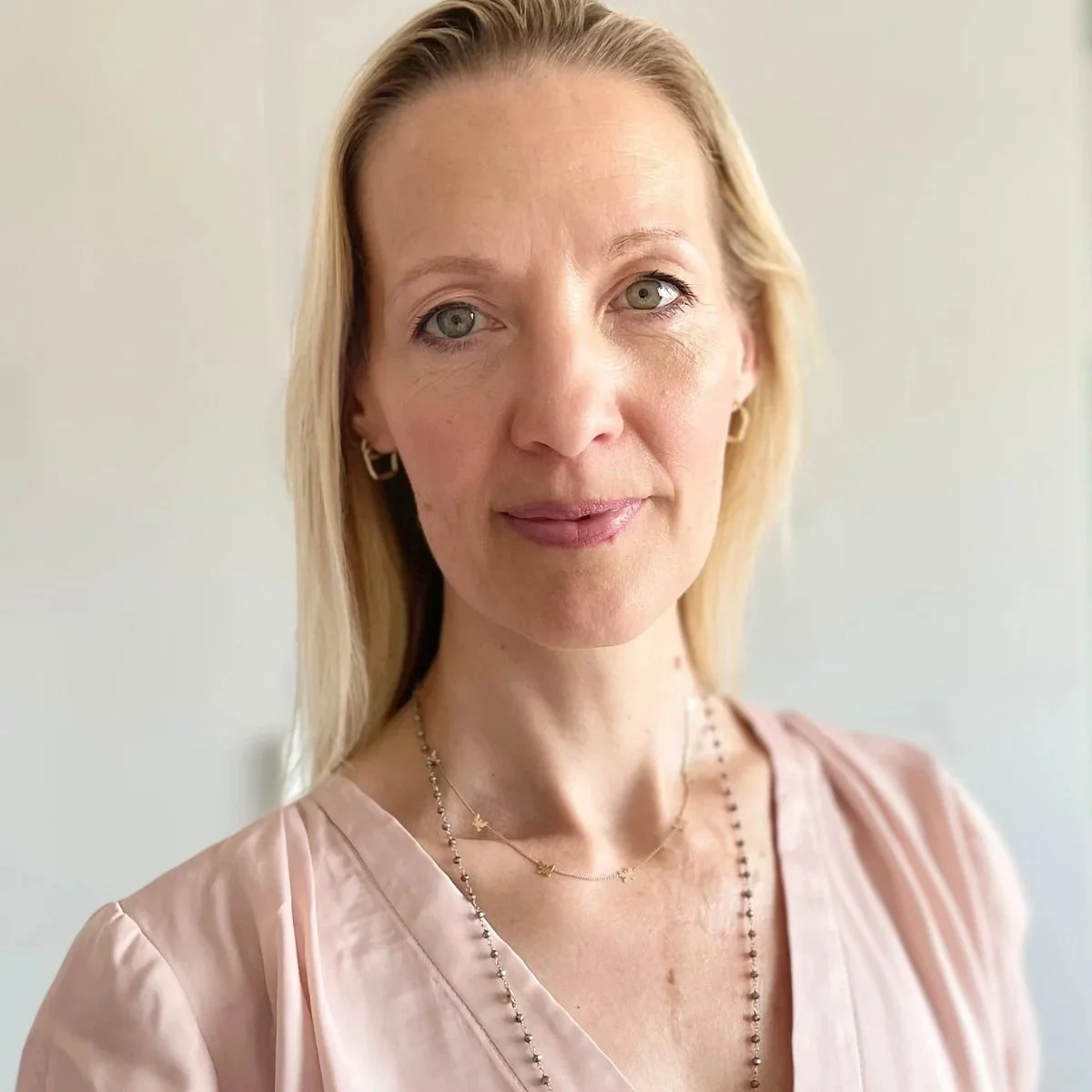 Headshot of Isabelle Griffith in a soft pink blouse, warmly offering her testimonial for Moon Pause