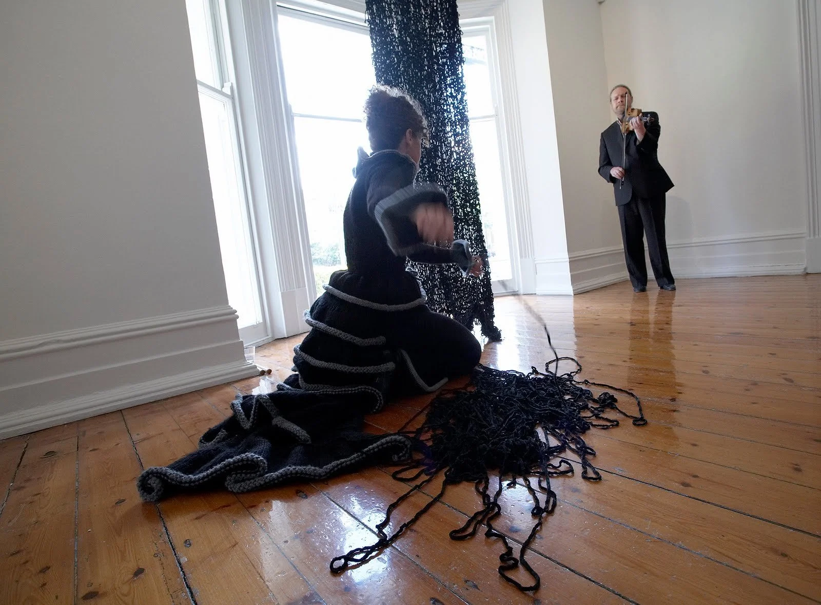 Craig Woodward plays folk ballads while McDonald performs mourning rituals