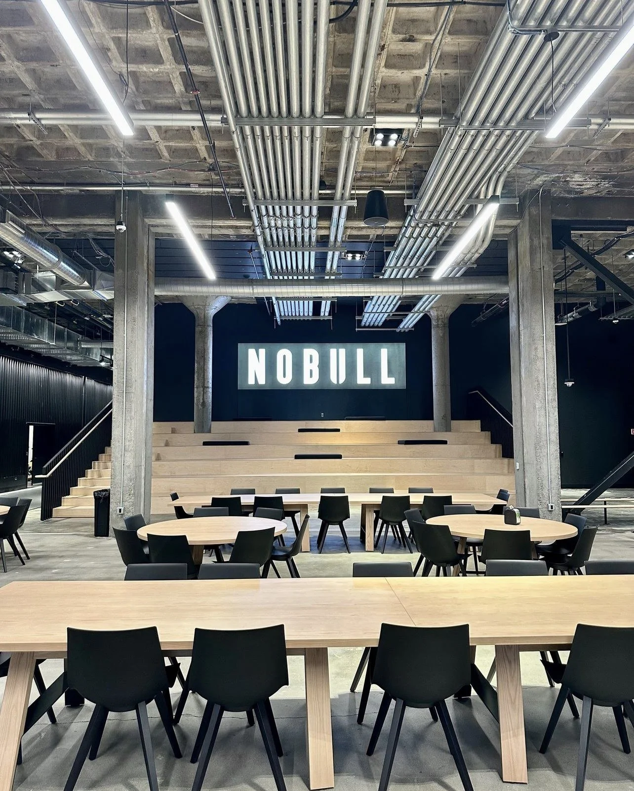NOBULL HQ — Amphitheater seating & white oak tables