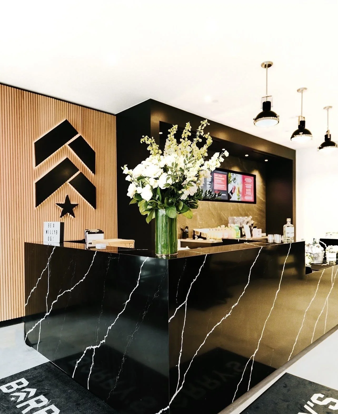 Barry's — Reception desk & white oak slat wall