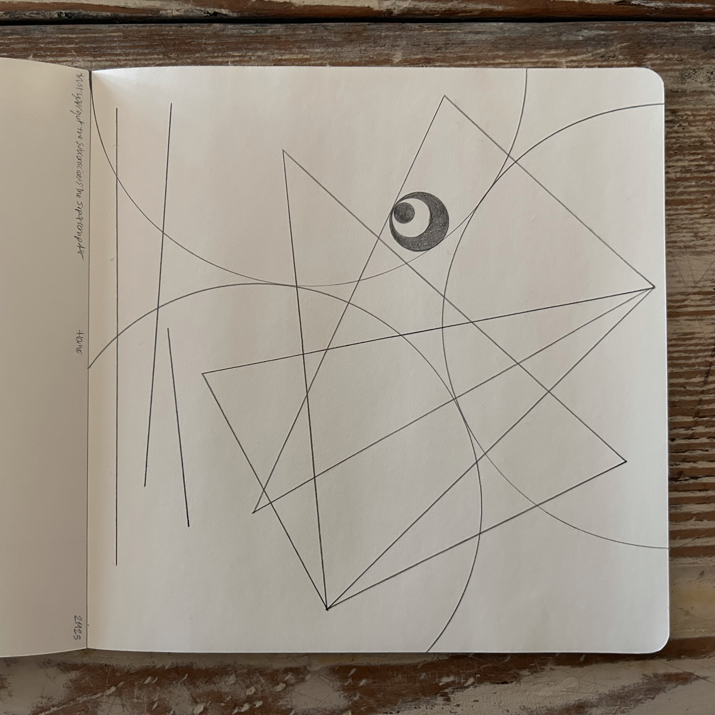 A sketch with geometric shapes, lines, and a shaded eye in the upper right center on white paper.