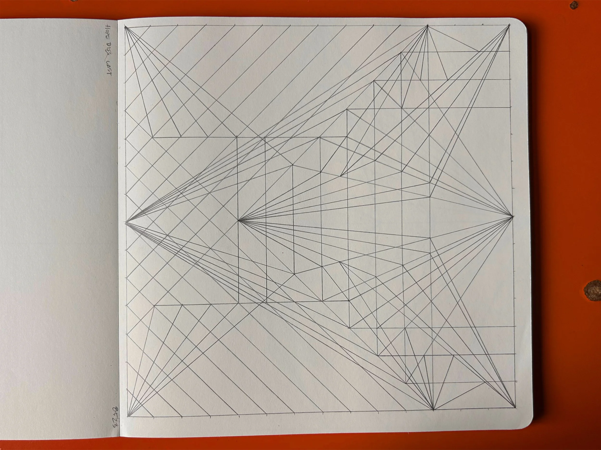 A notebook page with a geometric line drawing consisting of interconnected triangles and other polygons, with some lines radiating from the middle and forming a complex pattern.